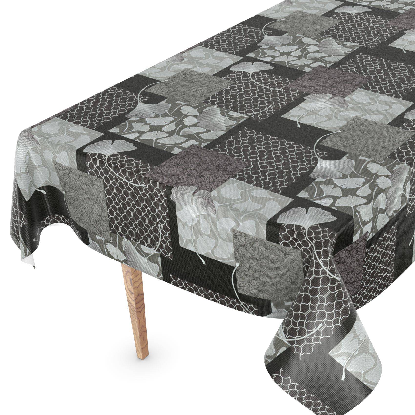 Ein rechteckiger Esstisch, bedeckt mit einer Tischdecke mit schwarzem, grauem und weißem Patchwork-Muster, die über die Kanten hinunter hängt.