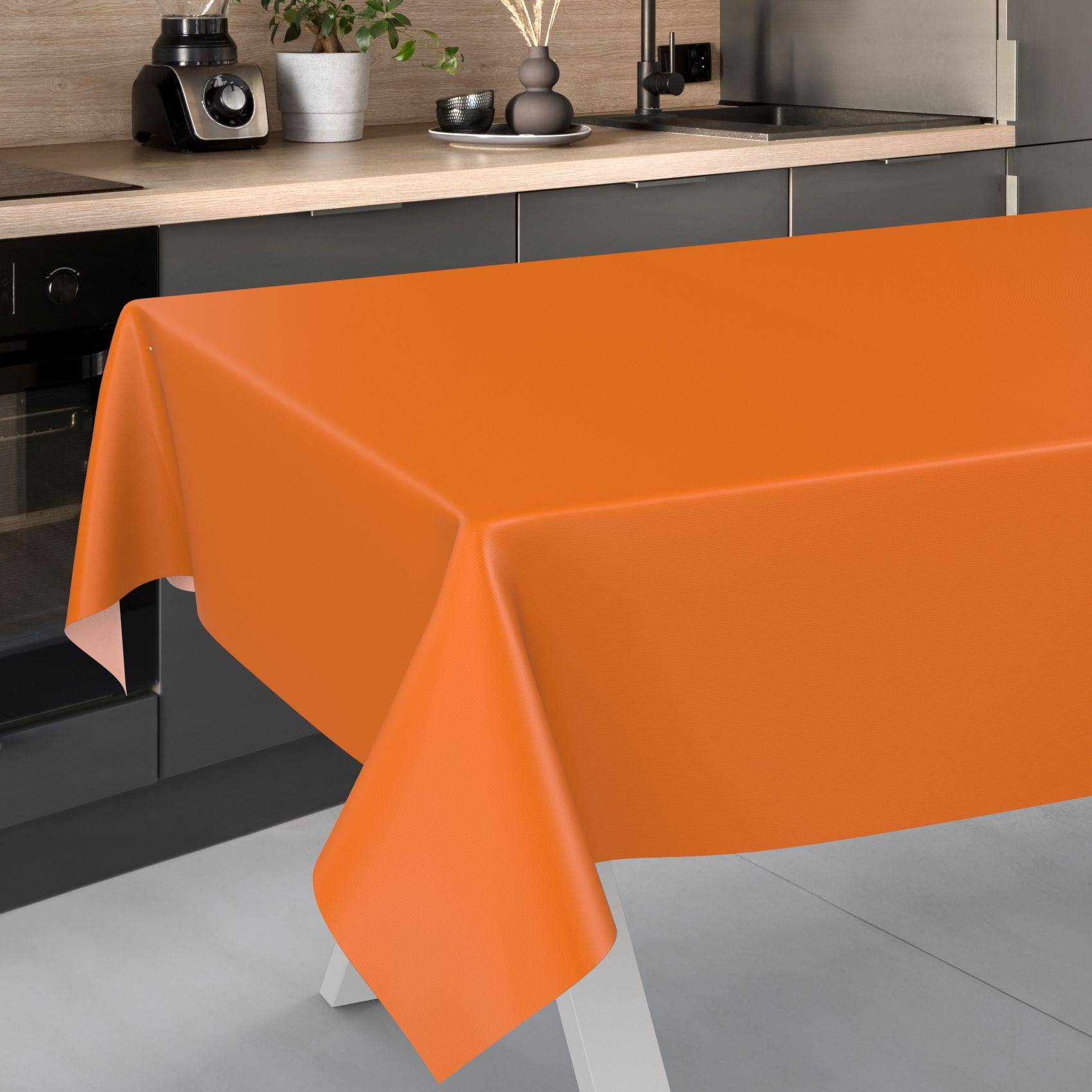 Leuchtend orangene Tischdecke, die über einen Esstisch in einer modernen Küche drapiert ist.