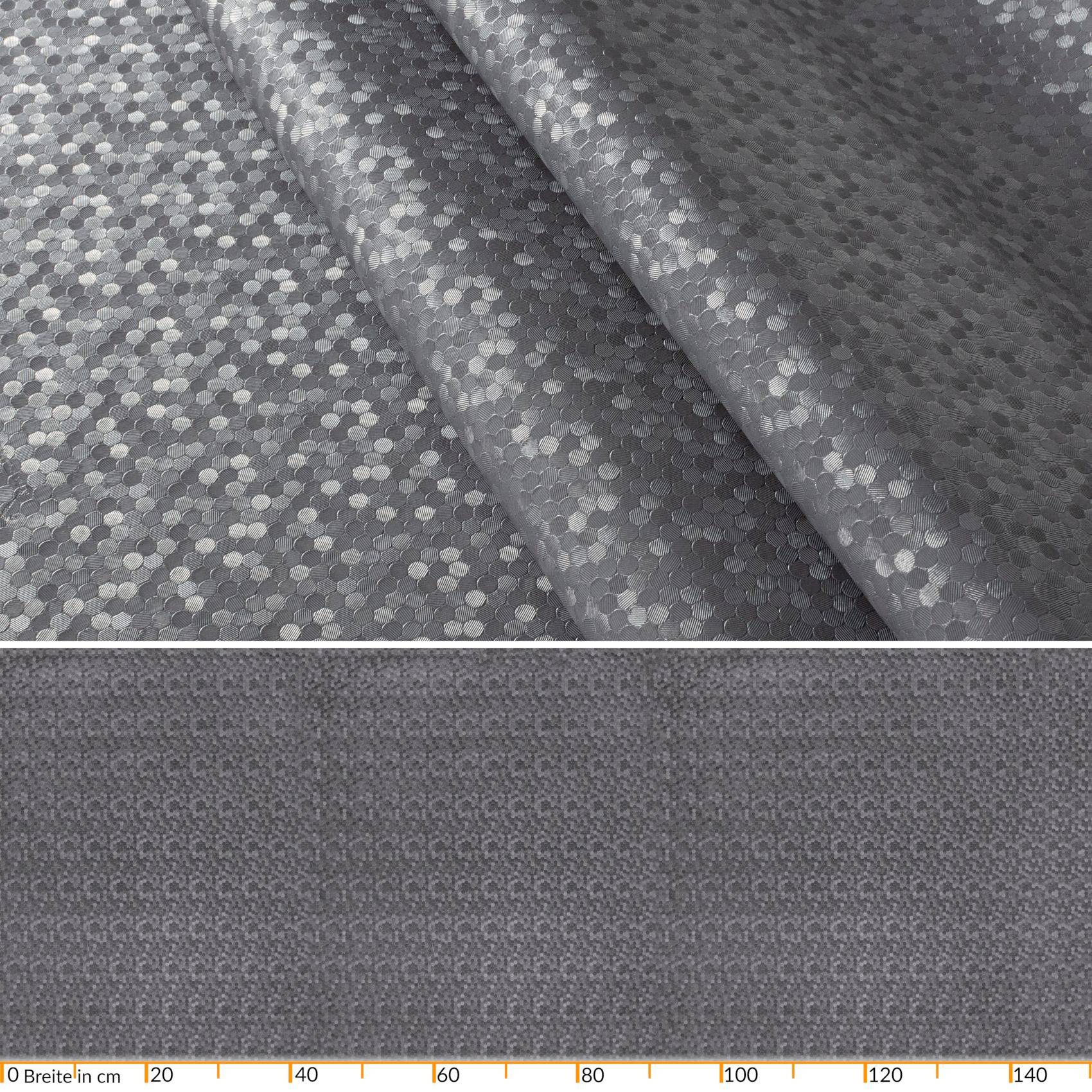 Grau gemusterter Stoff in Nahaufnahme, mit gefälteltem Material oben und einem flachen Bereich unten neben einem Zentimeterlineal als Größenreferenz.