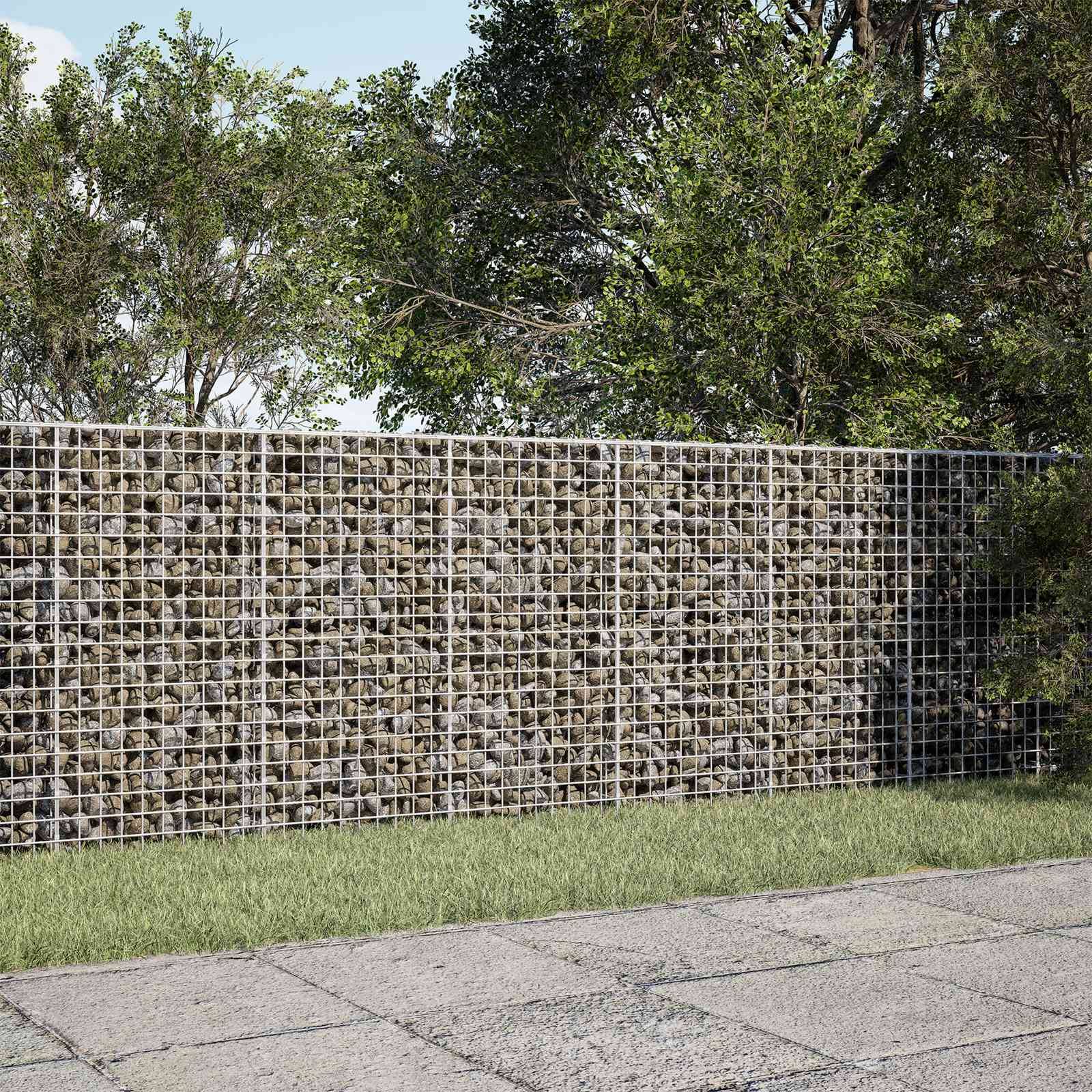 Gabionensteinmauer hinter einem Grünstreifen und gepflastertem Gehweg, mit Bäumen overhead in einer parkähnlichen Außenumgebung.