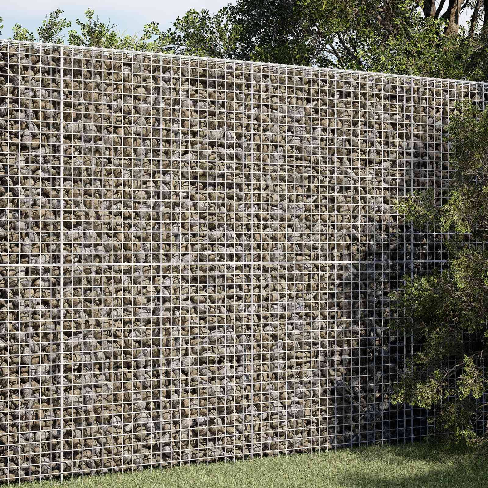 Eine Steinfüllung-Drahtgitterstützmauer mit Bäumen und Gras davor und darüber.