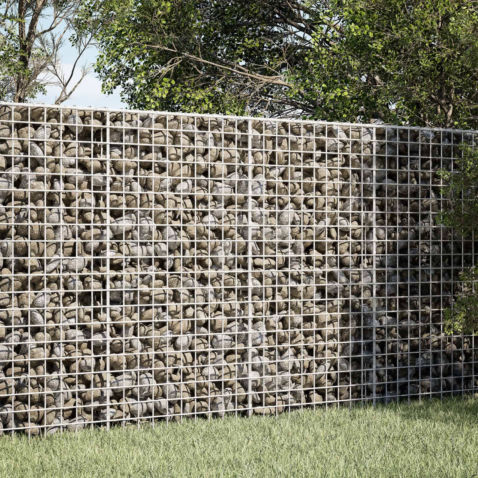 Drahtkörbe mit Steinen gefüllt, die als Mauer neben Gras und Bäumen im Freien stehen.