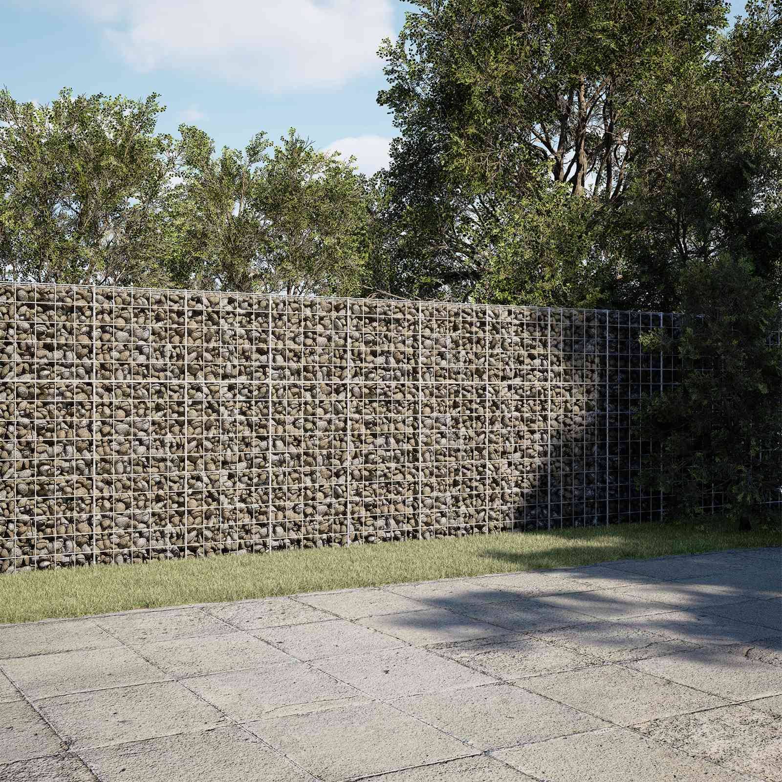 Eine mit Steinen gefüllte Drahtgitterstützwand neben einem gepflasterten Gehweg, mit Bäumen und Gras dahinter.