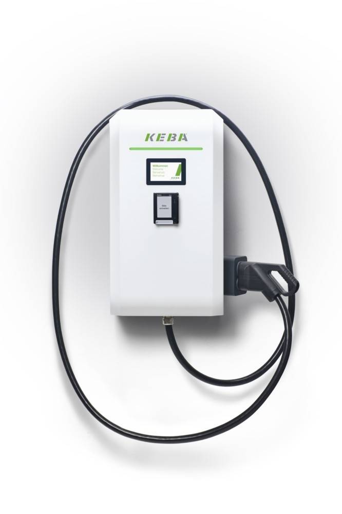Wandmontierte KEBA-Elektrofahrzeug-Ladestation mit aufgerolltem schwarzem Ladekabel und Stecker auf weißem Hintergrund.