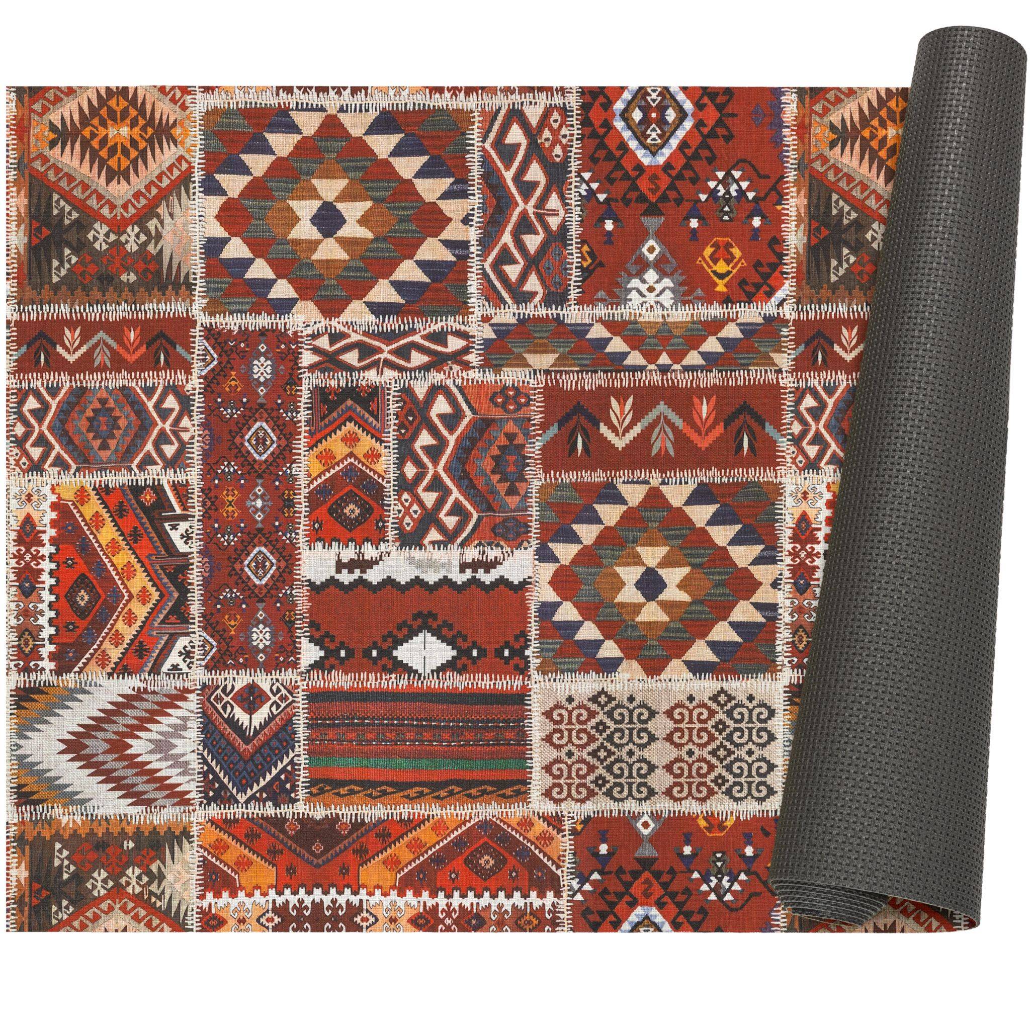 Aufgerollter gemusterter Teppich mit rot, orange, blau und creme geometrischem Patchwork-Design auf weißem Hintergrund.