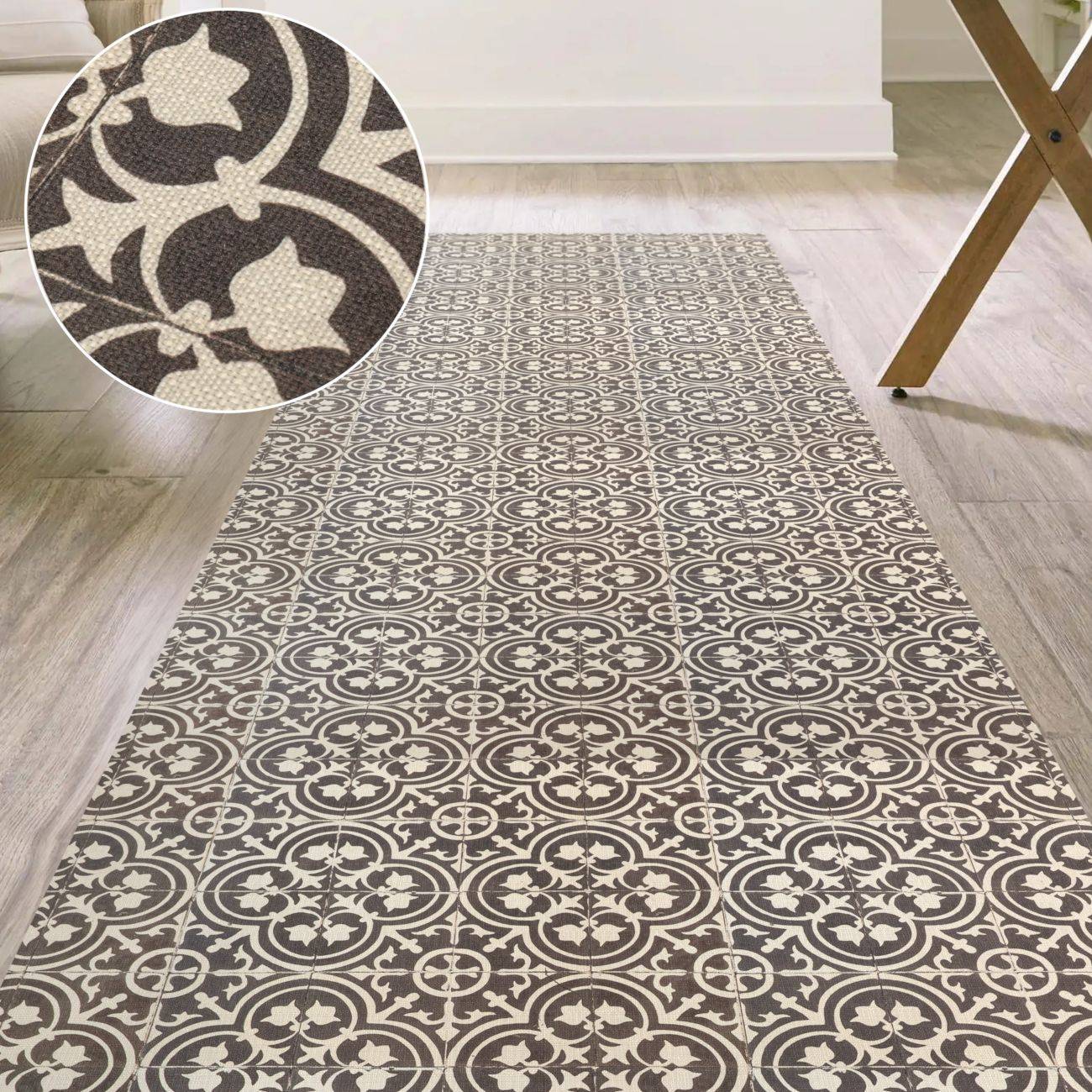 Braun-creme gemusterter Bereichsteppich auf hellem Holzfußboden, dargestellt mit einer Nahaufnahme des sich wiederholenden fliesenartigen Blumenmotivs.