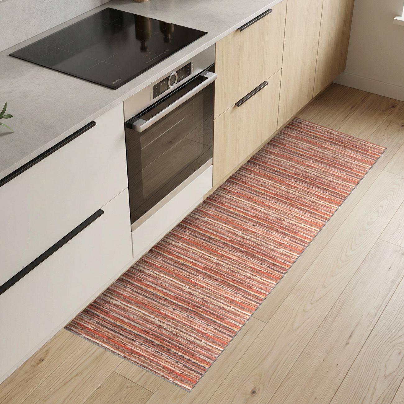 Moderne Küche mit hellholzfronten Schränken, eingebautem Backofen und schwarzem Kochfeld neben einem langen gestreiften Läufer auf Holzboden.