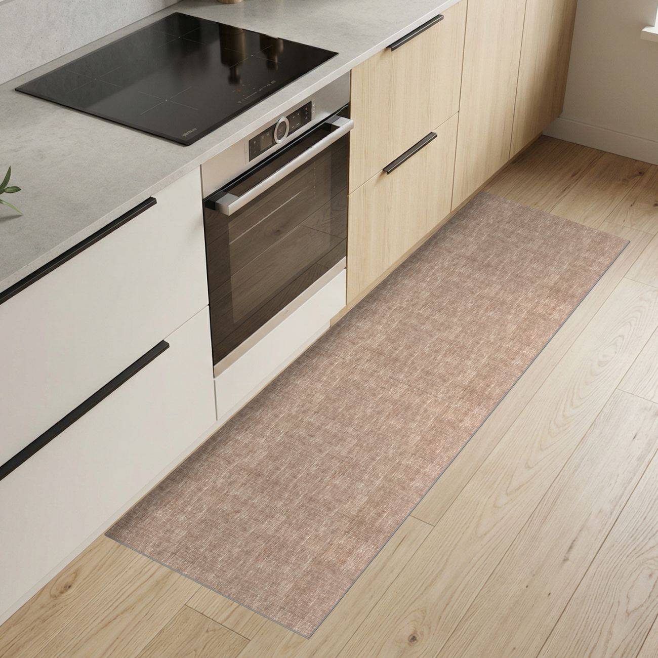 Moderne Küche mit integriertem Ofen und schwarzem Kochfeld, hellen Holzschränken und einem langen beigen Läuferteppich auf dem Boden.