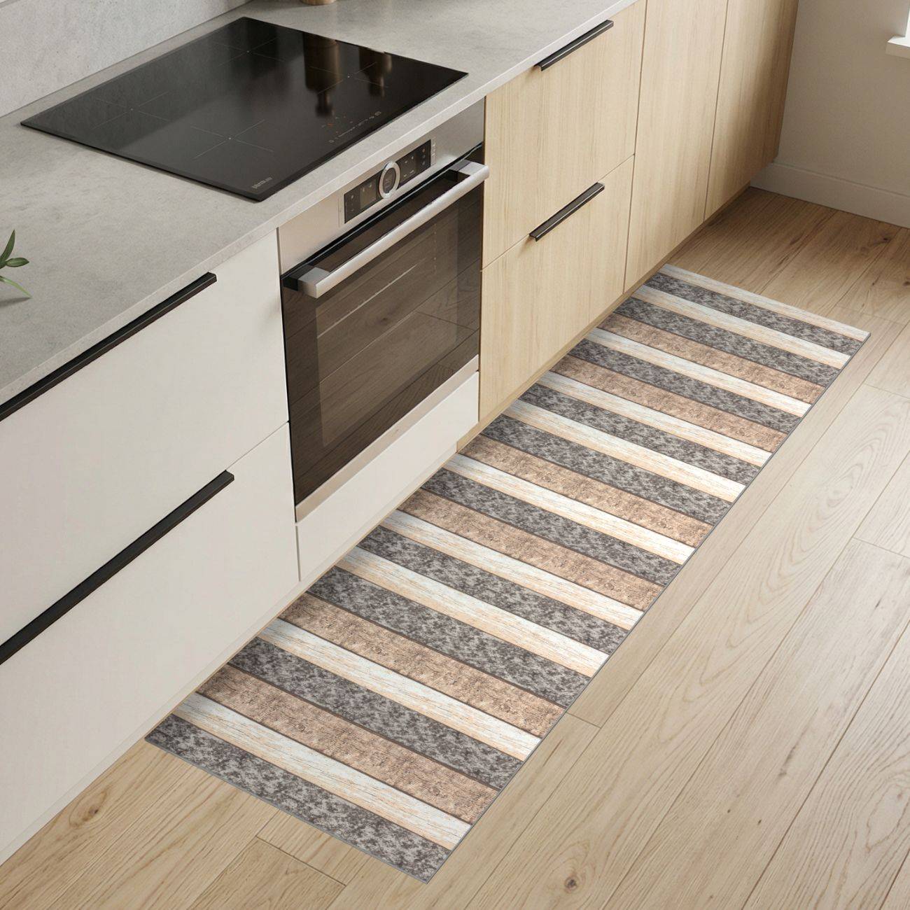 Moderne Küche mit hellen Holzschränken, eingebautem Ofen und schwarzem Kochfeld, sowie einem langen gestreiften Läuferteppich auf dem Boden.