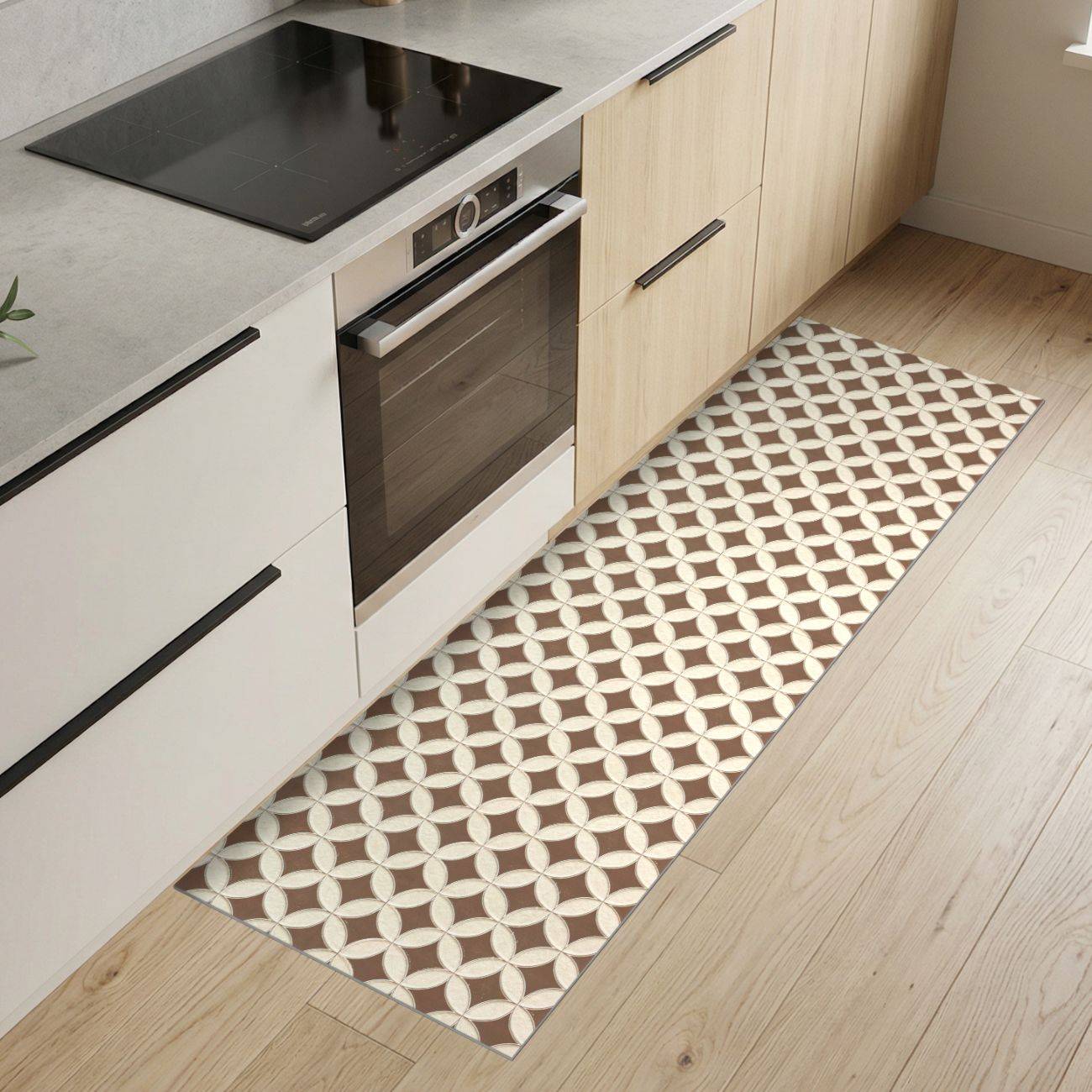 Moderne Küche mit hellen Holzschränken, eingebautem Ofen und Kochfeld sowie einem gemusterten Läuferteppich auf dem Boden.
