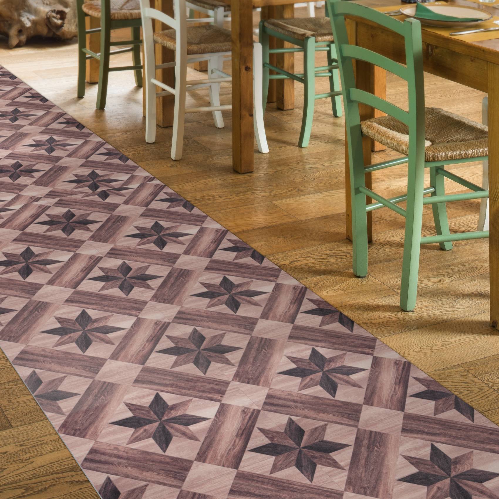 Gemusterter violetter Teppich mit Sternenmustern neben einem Holzspeisebereich mit Pastellstühlen und Tischen.
