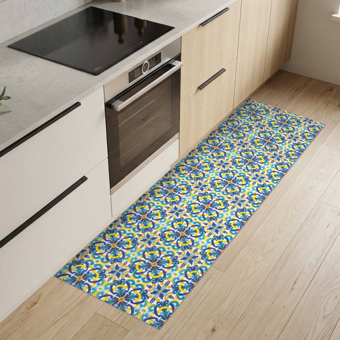 Moderne Küche mit hellem Holzschrank, eingebautem Ofen, schwarzem Kochfeld und einem langen farbigen gemusterten Küchenlaufer