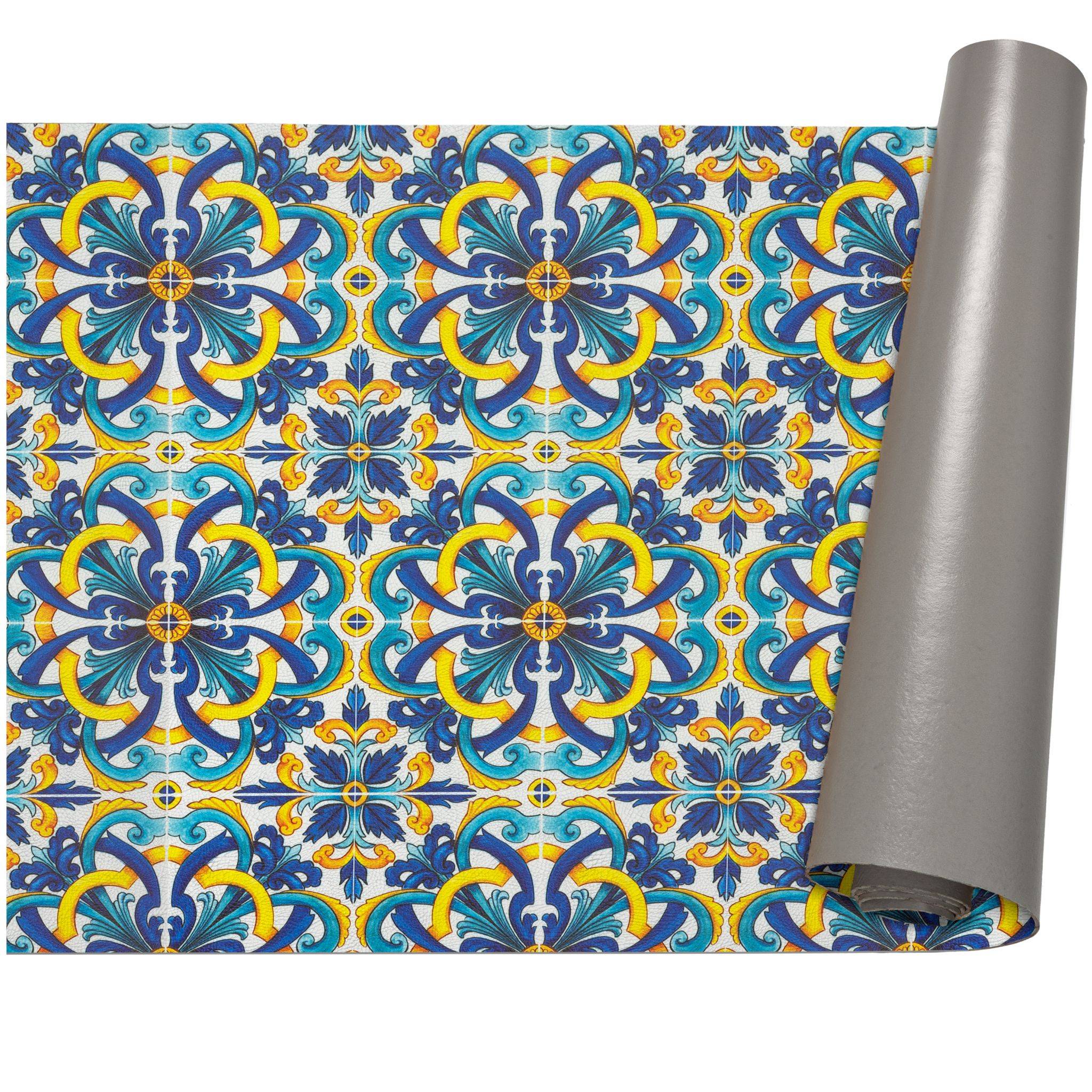 Dekorative gemusterte Tapete oder Geschenkpapier mit blauen, gelben und blaugrünen floralen Kachelmotiven, teilweise an der rechten Kante aufgerollt.