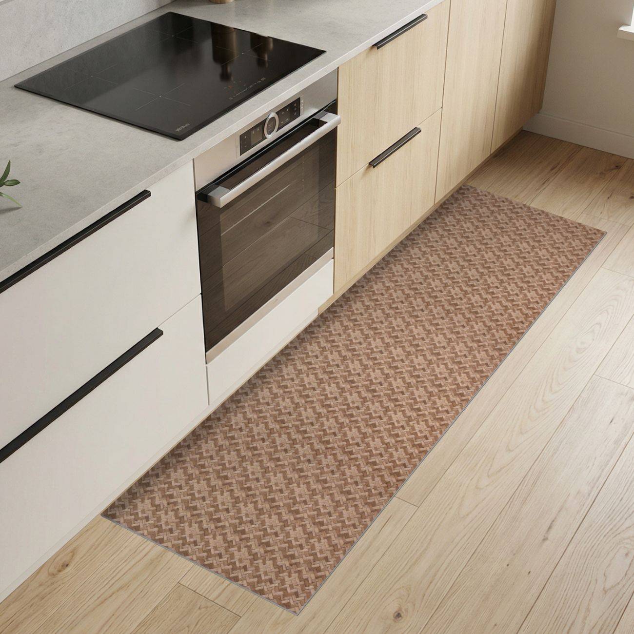 Moderne Küche mit schwarzem Kochfeld, eingebautem Ofen, hellen Holzschränken und einem schmalen gemusterten Läufer auf dem Boden.