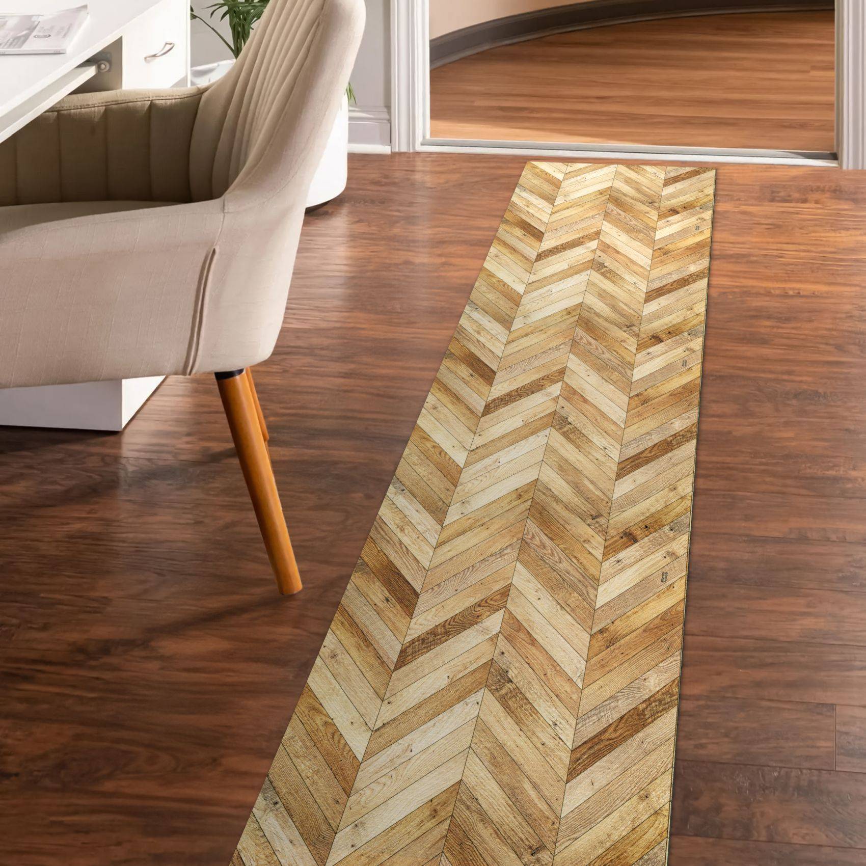 Schmaler Läufer mit Fischgrätmuster auf einem Holzboden neben einem beige gepolsterten Stuhl in einem modernen Zimmer.