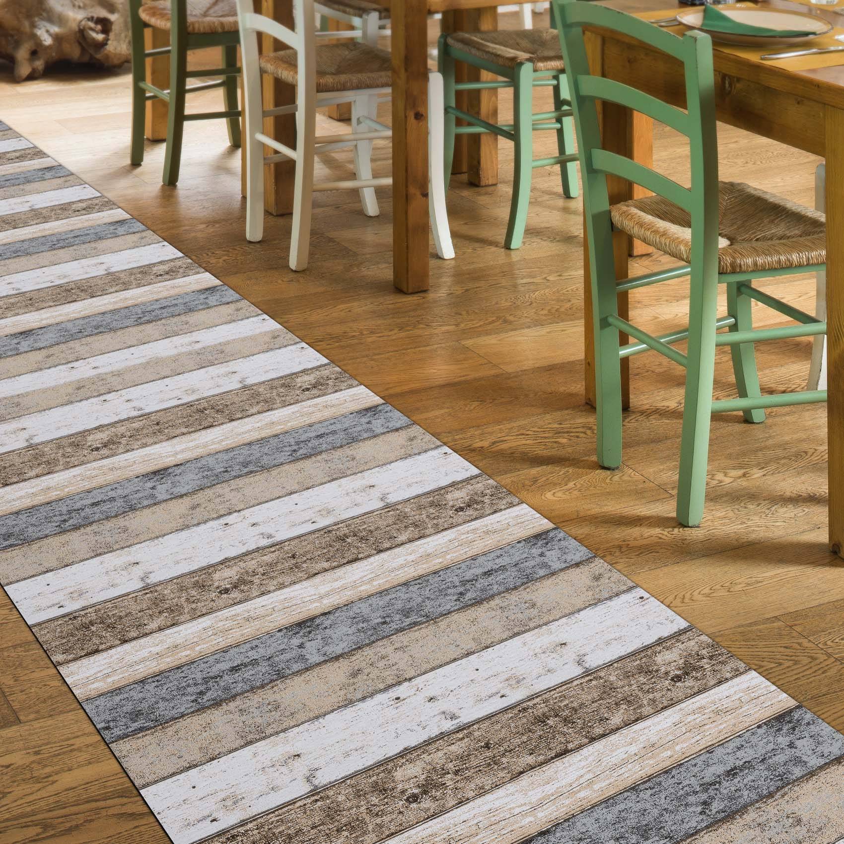 Gewebter Läufer mit Streifen in Weiß, Grau und Beige auf einem Holzboden neben Esszimmerstühlen und einem Tisch.