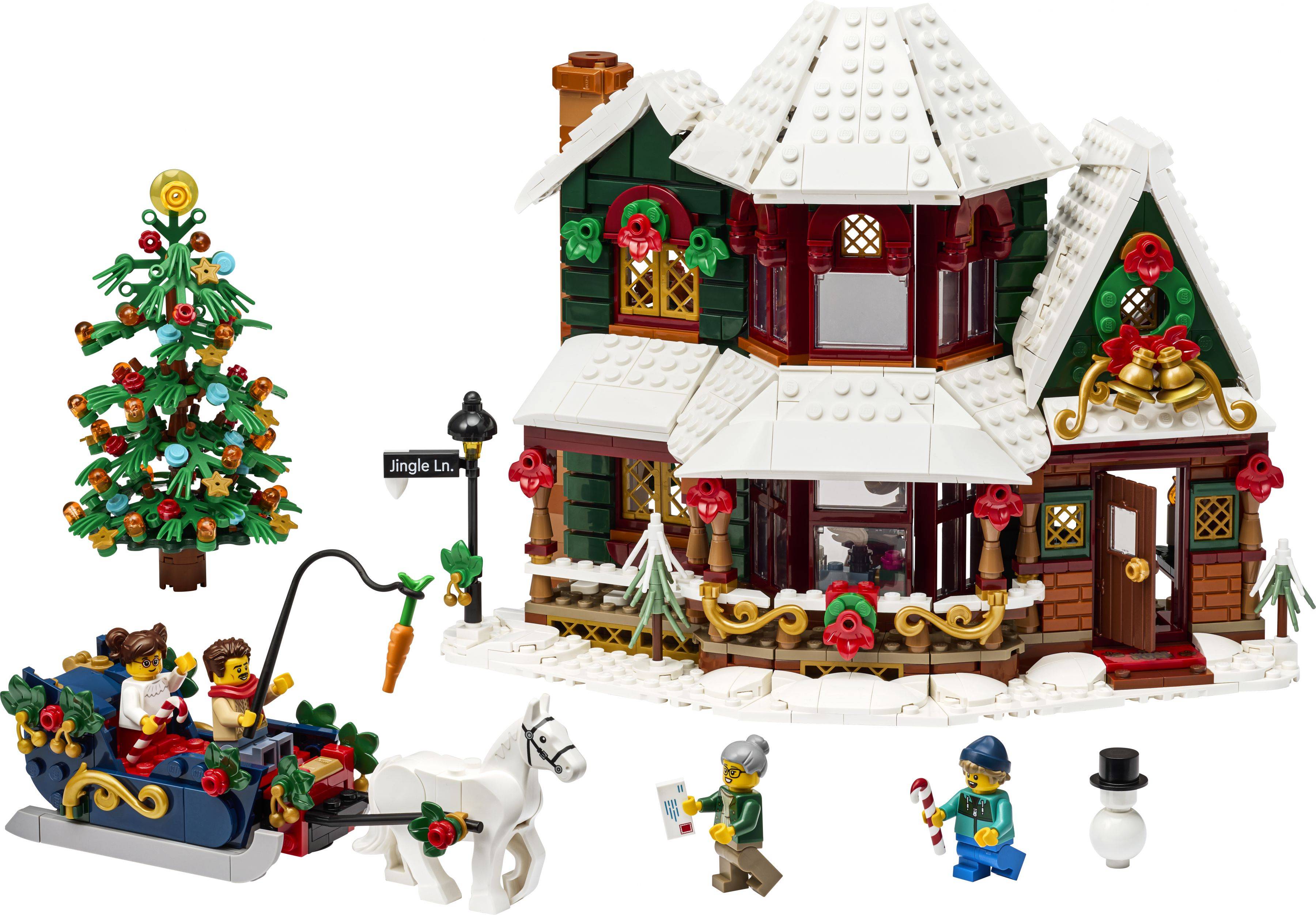 LEGO-Weihnachtsszenerie mit einem dekorierten Haus, einem Baum, einem Schlitten mit Figuren, einem Pferd und kleinen Zubehörfiguren auf weißem Hintergrund.