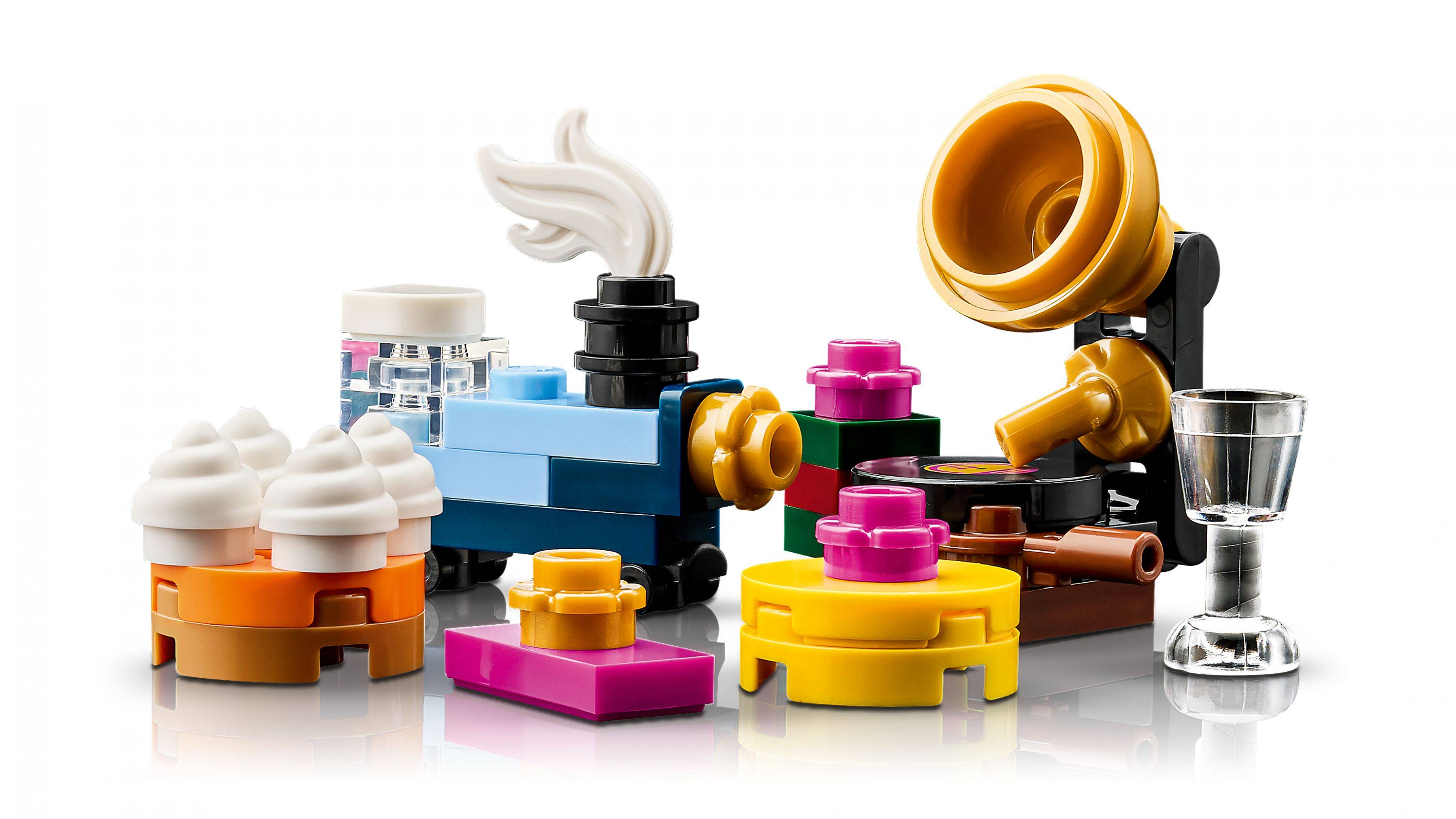 Sortierte LEGO-ähnliche Spielzeugbausteine mit einer goldenen Roboterfigur und kleinem durchsichtigem Becher auf weißem Hintergrund