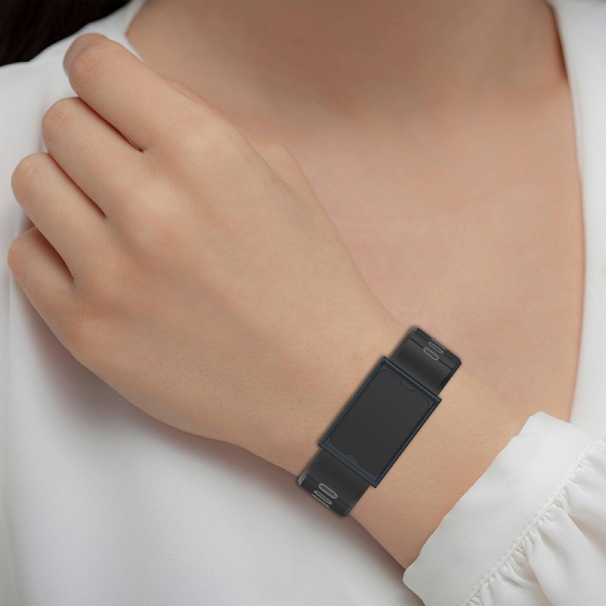 Nahaufnahme des Handgelenks einer Person, die eine schlanke schwarze rechteckige Smartwatch mit leerem Bildschirm trägt.