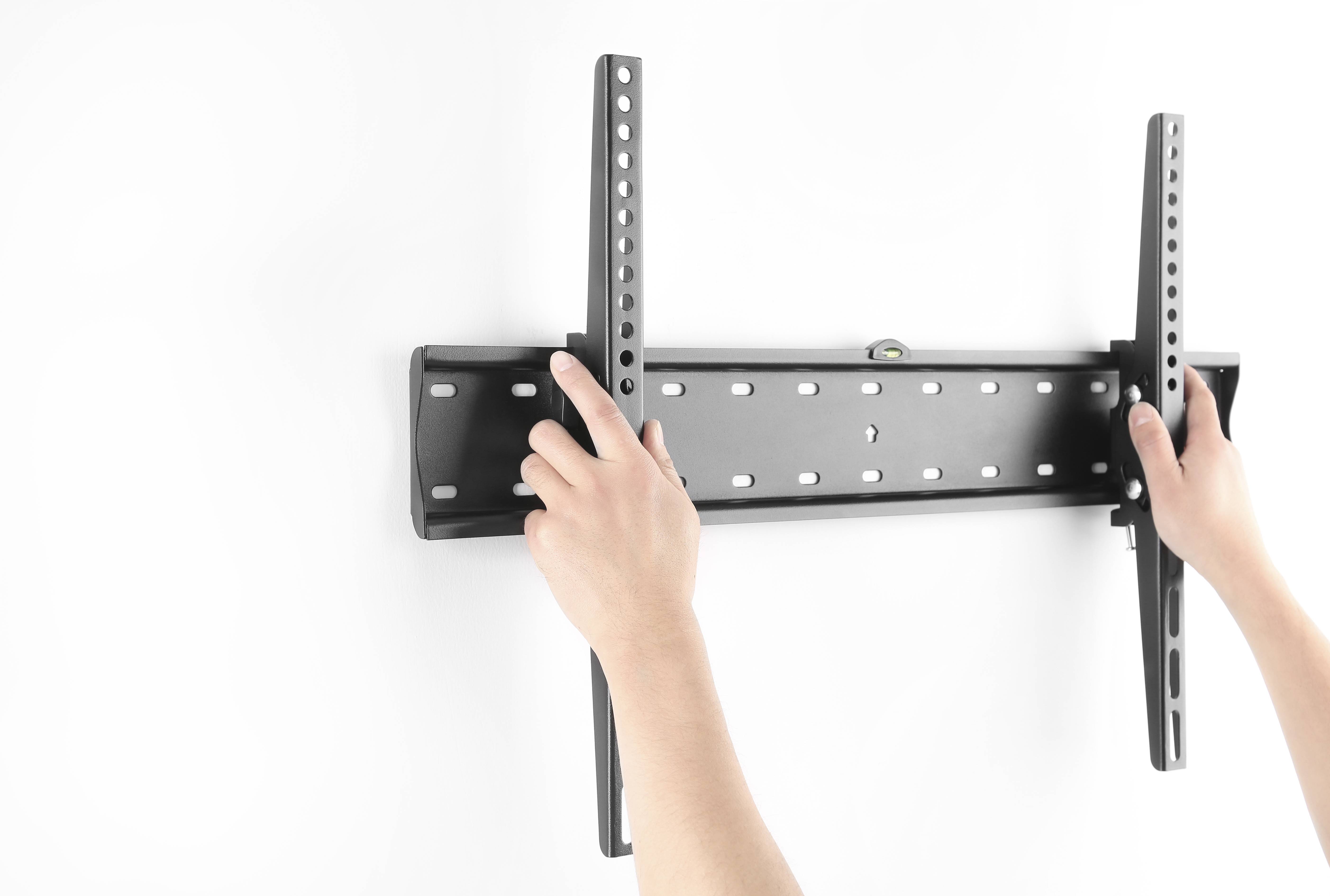 Hände montieren eine schwarze Fernseh-Wandhalterung an einer weißen Wand und passen zwei vertikale Schienen an der Montageplatte an.