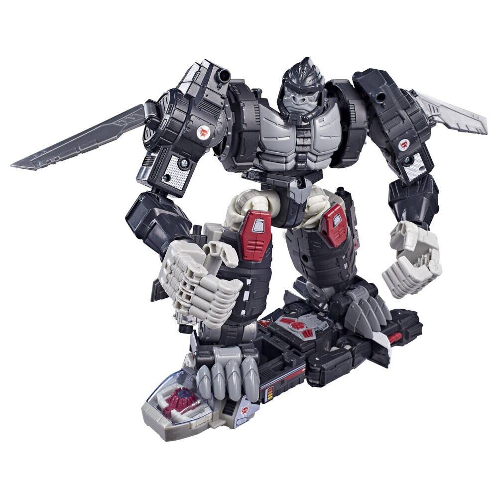 Ein Transformers-ähnliche Roboter-Actionfigur in kauernder Position auf einem schwarzroten Sockel, mit großen waffenähnlichen Schulterelementen und silbernen, schwarzen und roten Details.