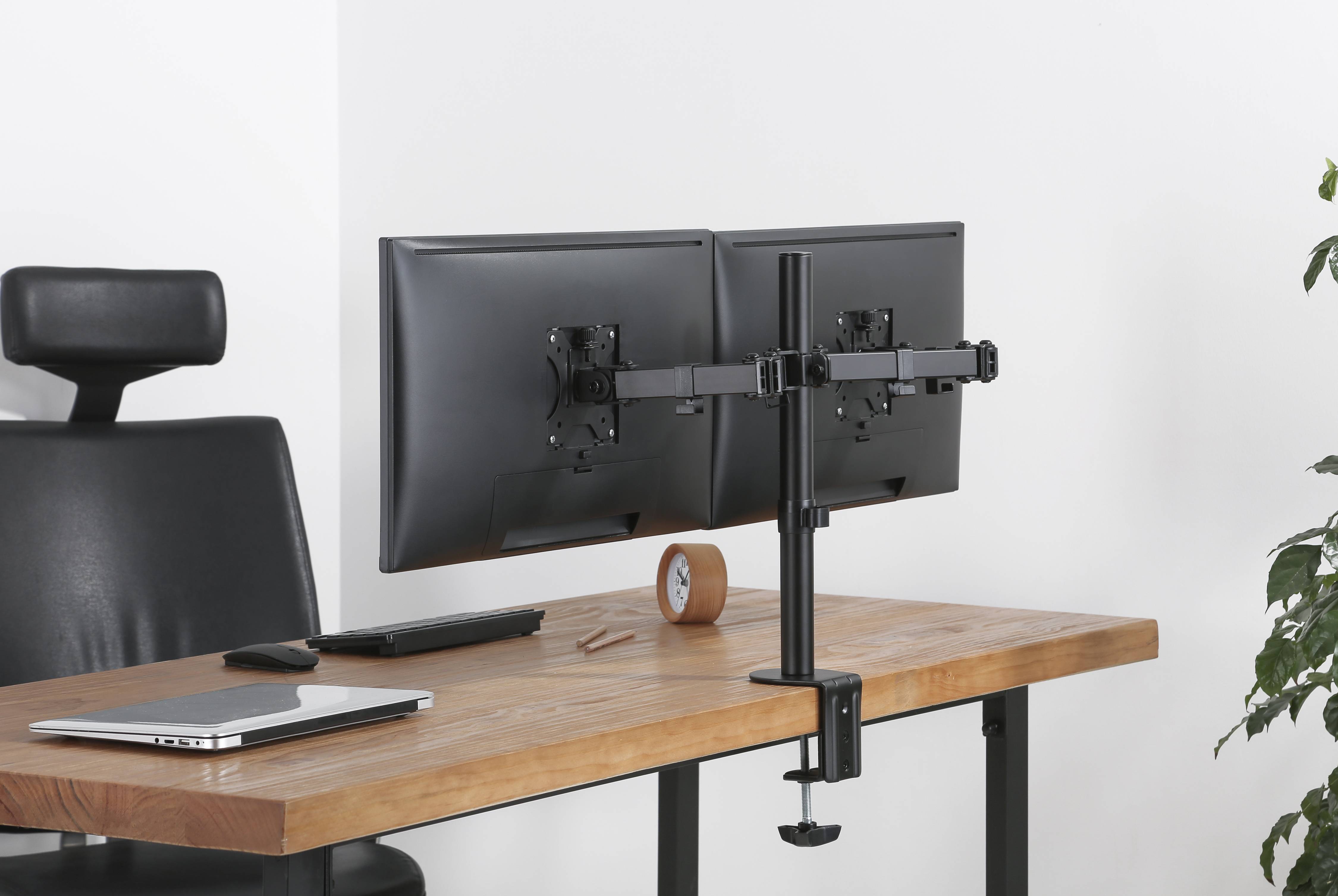 Dual-Monitor-Desktop-Workstation mit zwei Monitorarmen, die an einem Holzschreibtisch befestigt sind, plus Laptop, Tastatur, Maus und Stuhl in einem sauberen Büro-Setup.