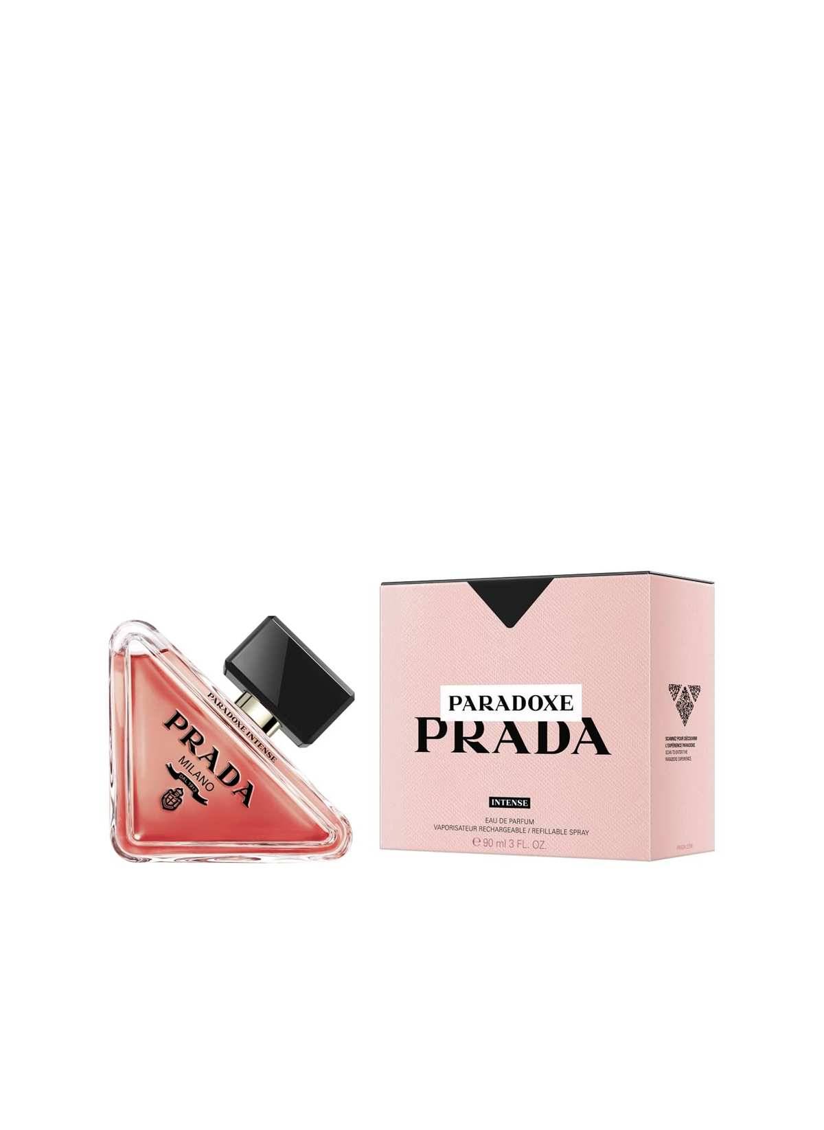 Prada Paradoxe Parfümflasche neben ihrer rosa Einzelhandelsschachtel auf weißem Hintergrund.