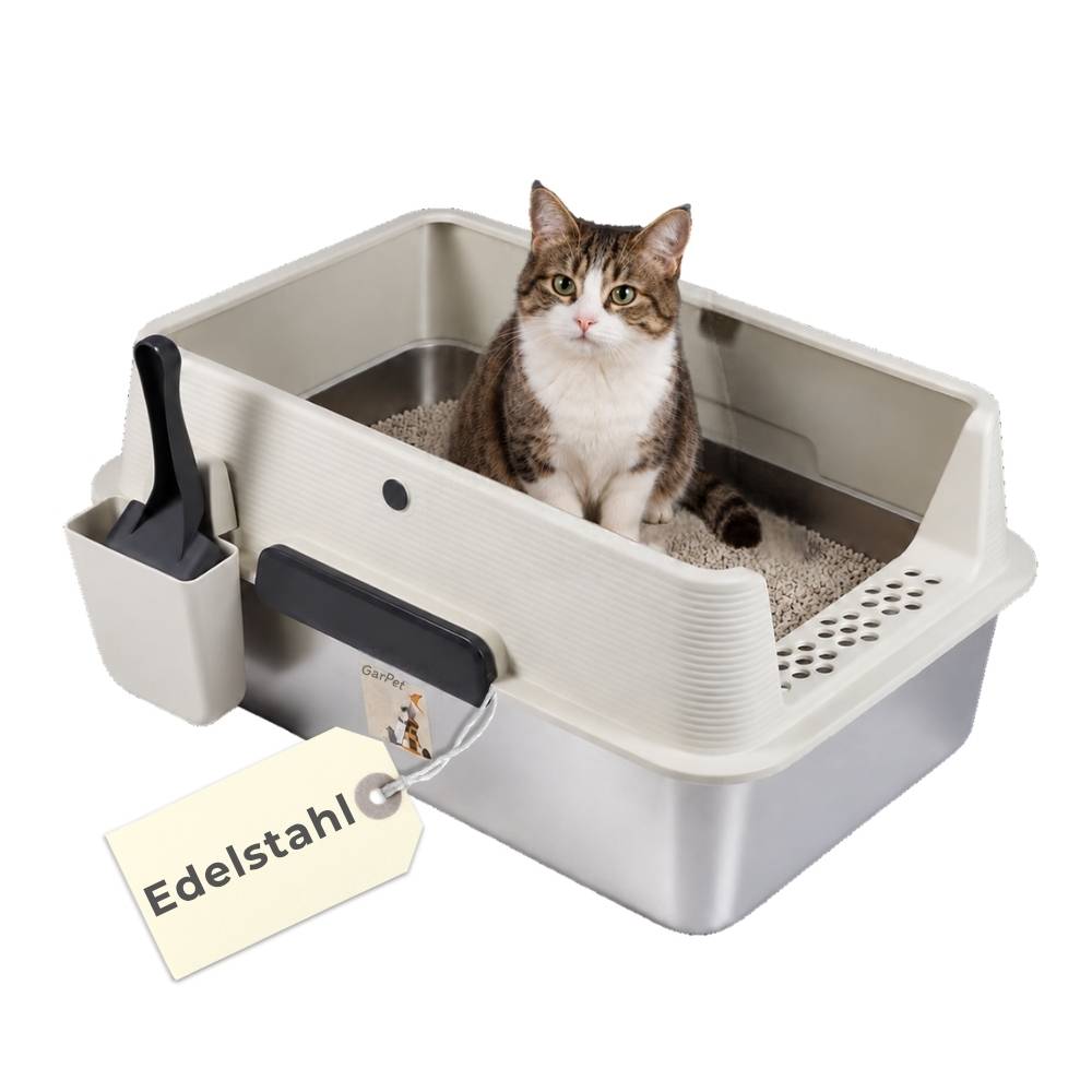 Getigerte Katze sitzt in einer beige abgedeckten Katzentoilette mit einem schwarzen Schaufelhalter; das Produktetikett zeigt 