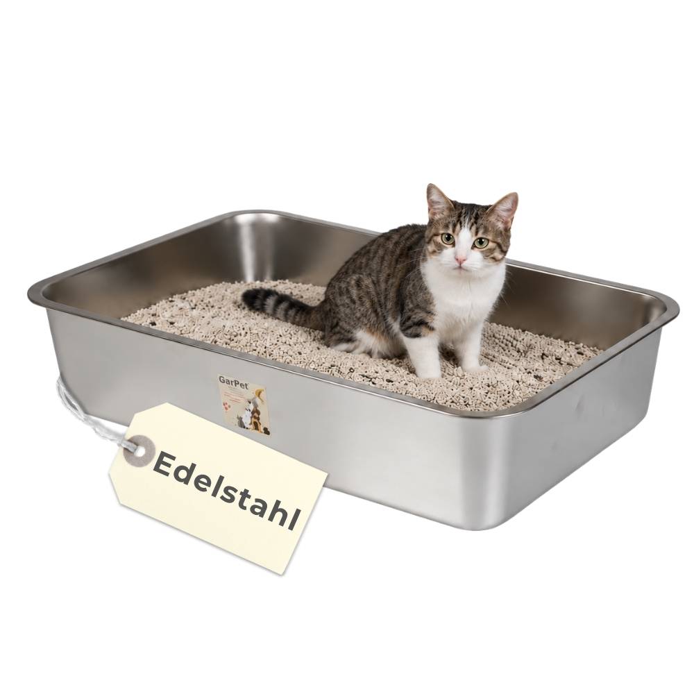 Katze sitzt in einer Edelstahl-Katzentoilette gefüllt mit Katzenstreu, mit einem Etikett mit der Aufschrift „Edelstahl