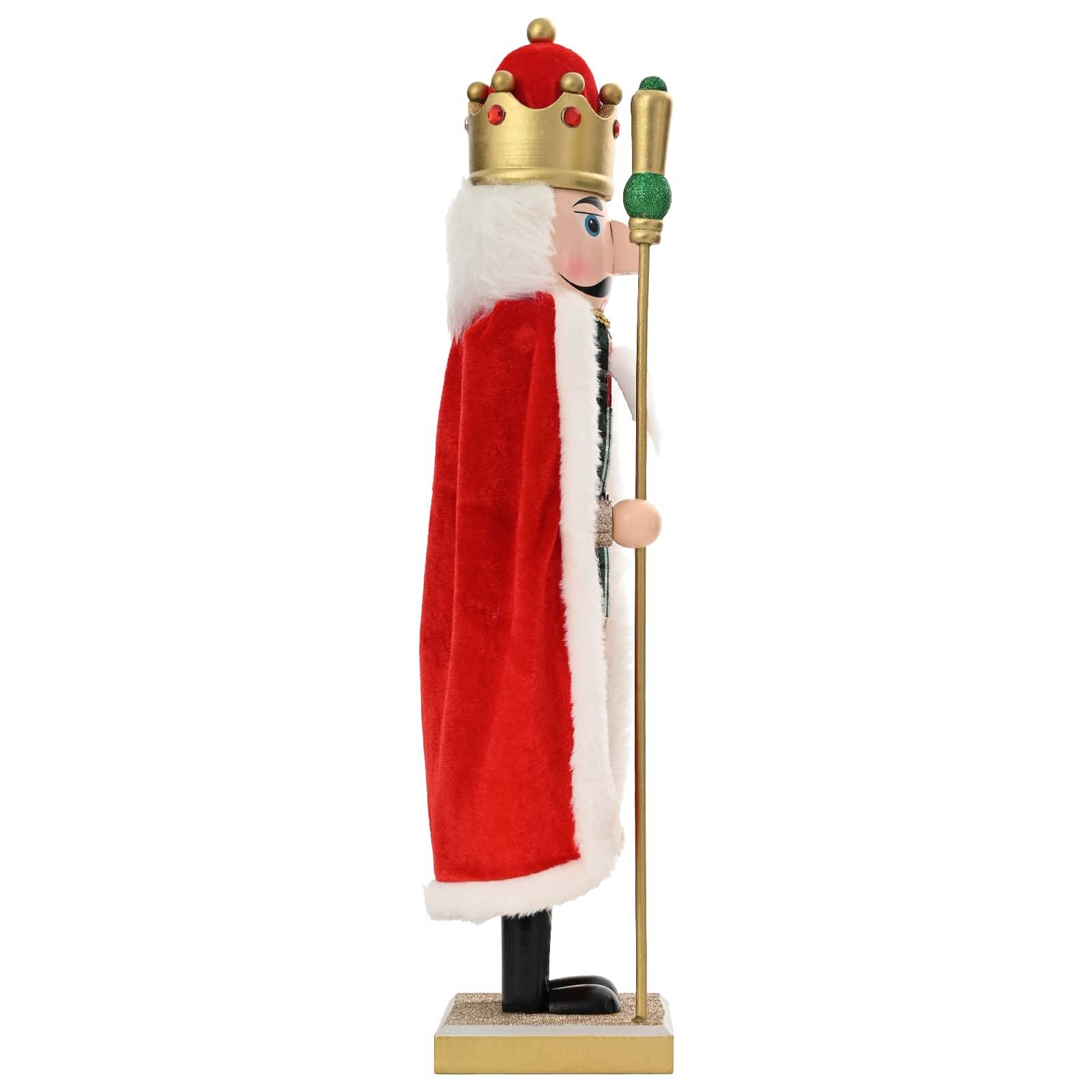 Seitenansicht einer hölzernen Nussknacker-König-Figur mit einer goldenen Krone, einem roten Samtkap und einem Stab auf weißem Hintergrund.