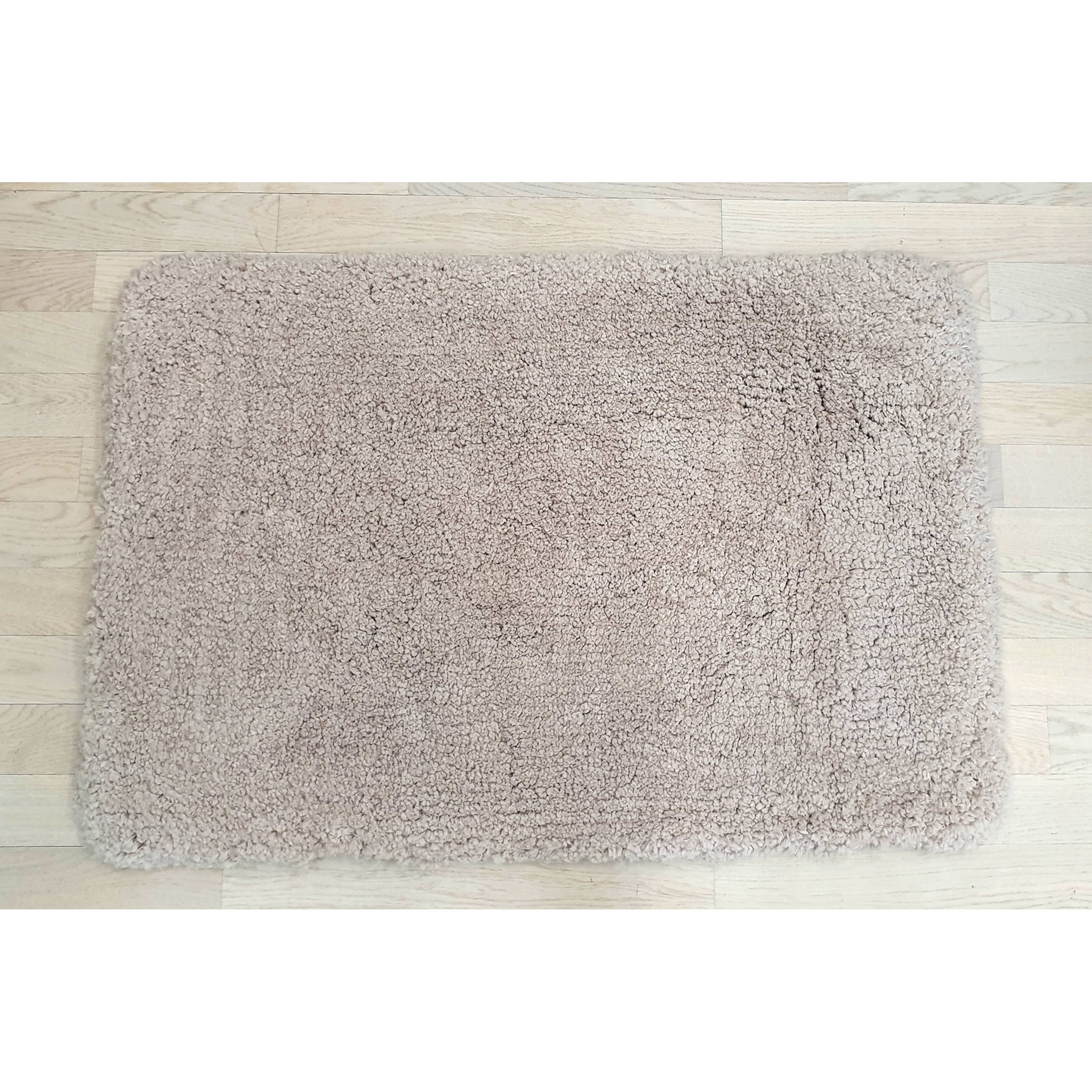 Rechteckige beige Hochflor-Badmatte auf hellem Holzboden, von oben betrachtet.