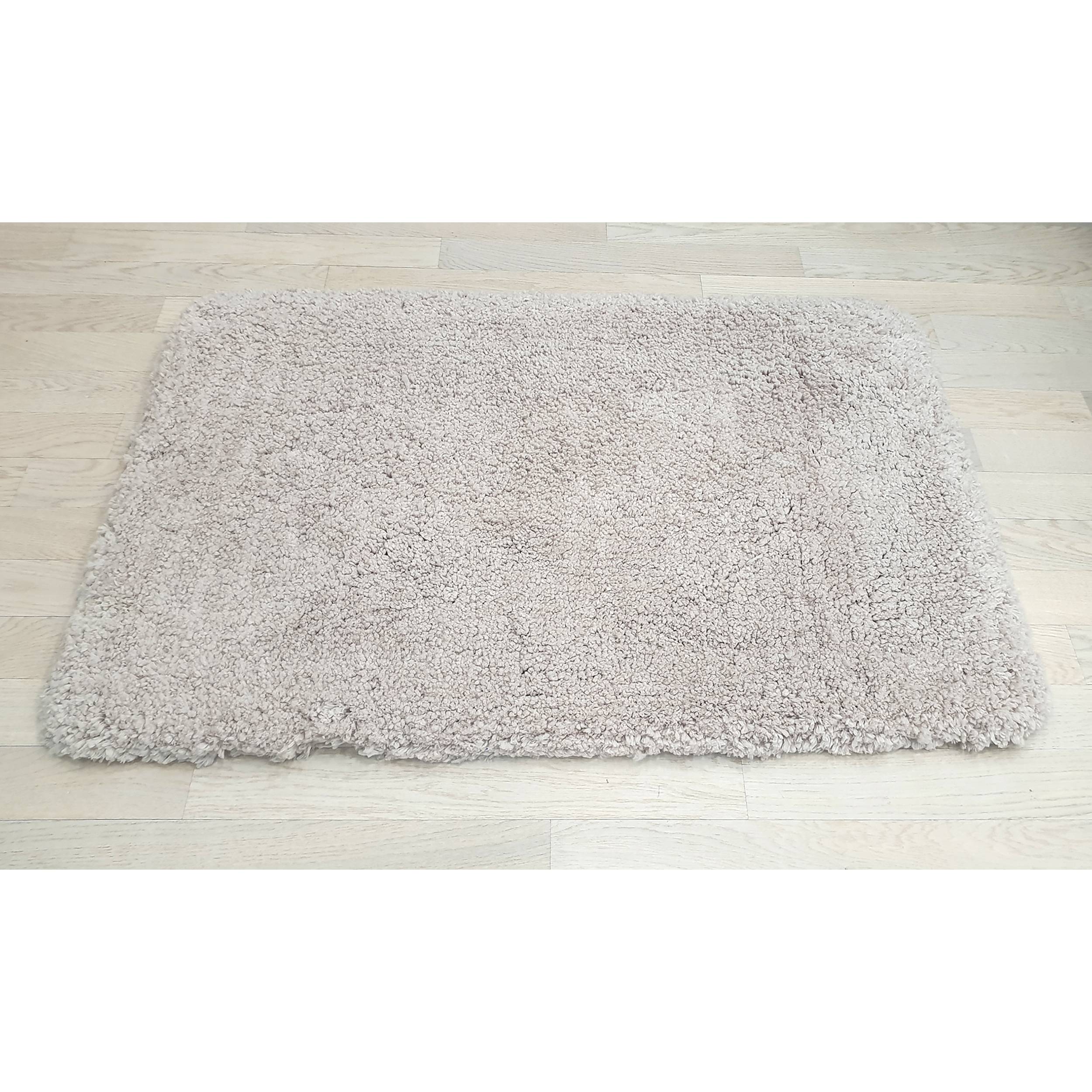 Ein heller beige Shag-Bereichsteppich auf einem hellen Holzboden.