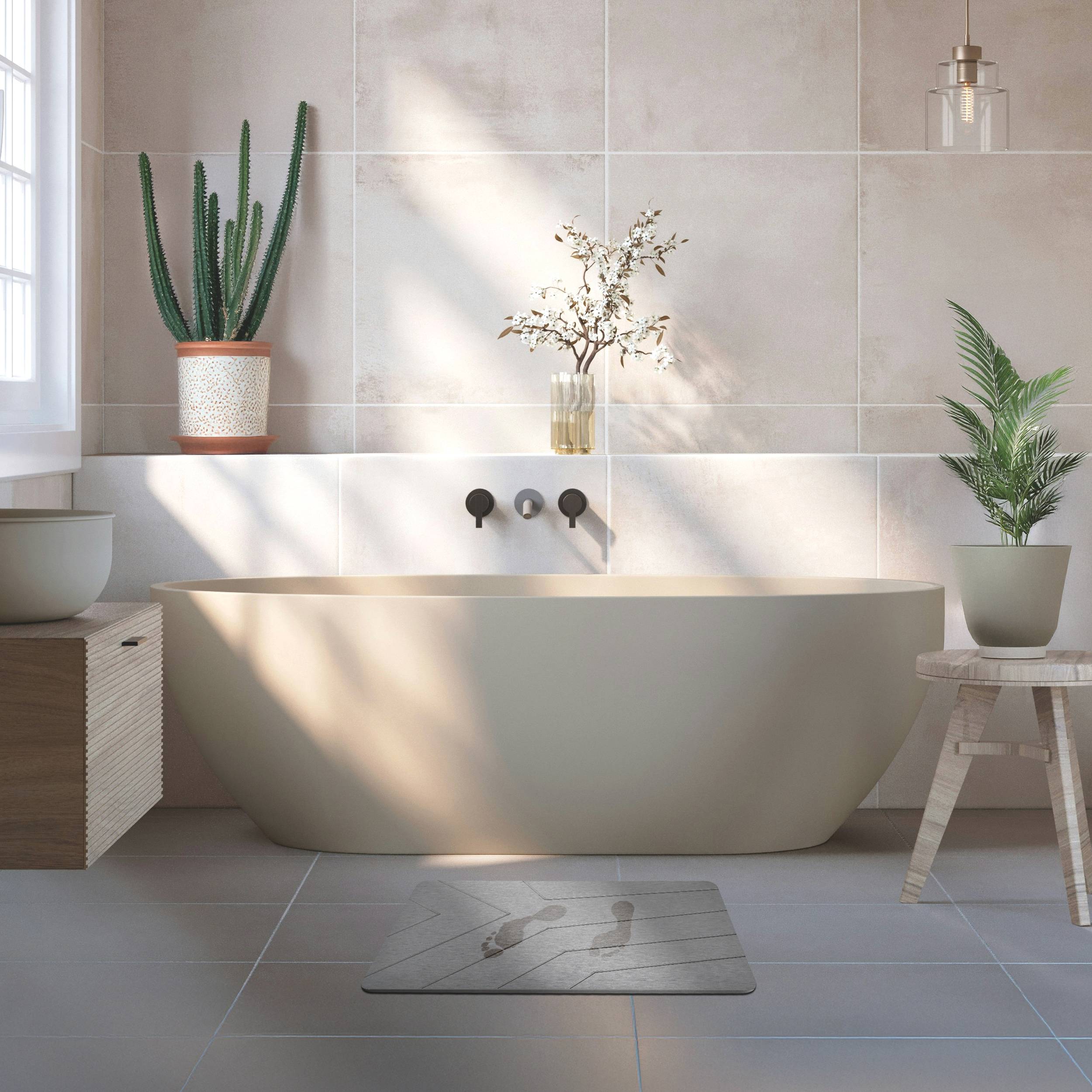Minimalistisches Badezimmer mit einer freistehenden Badewanne vor gekachelten Wänden, flankiert von Topfpflanzen und beleuchtet durch weiches Sonnenlicht.