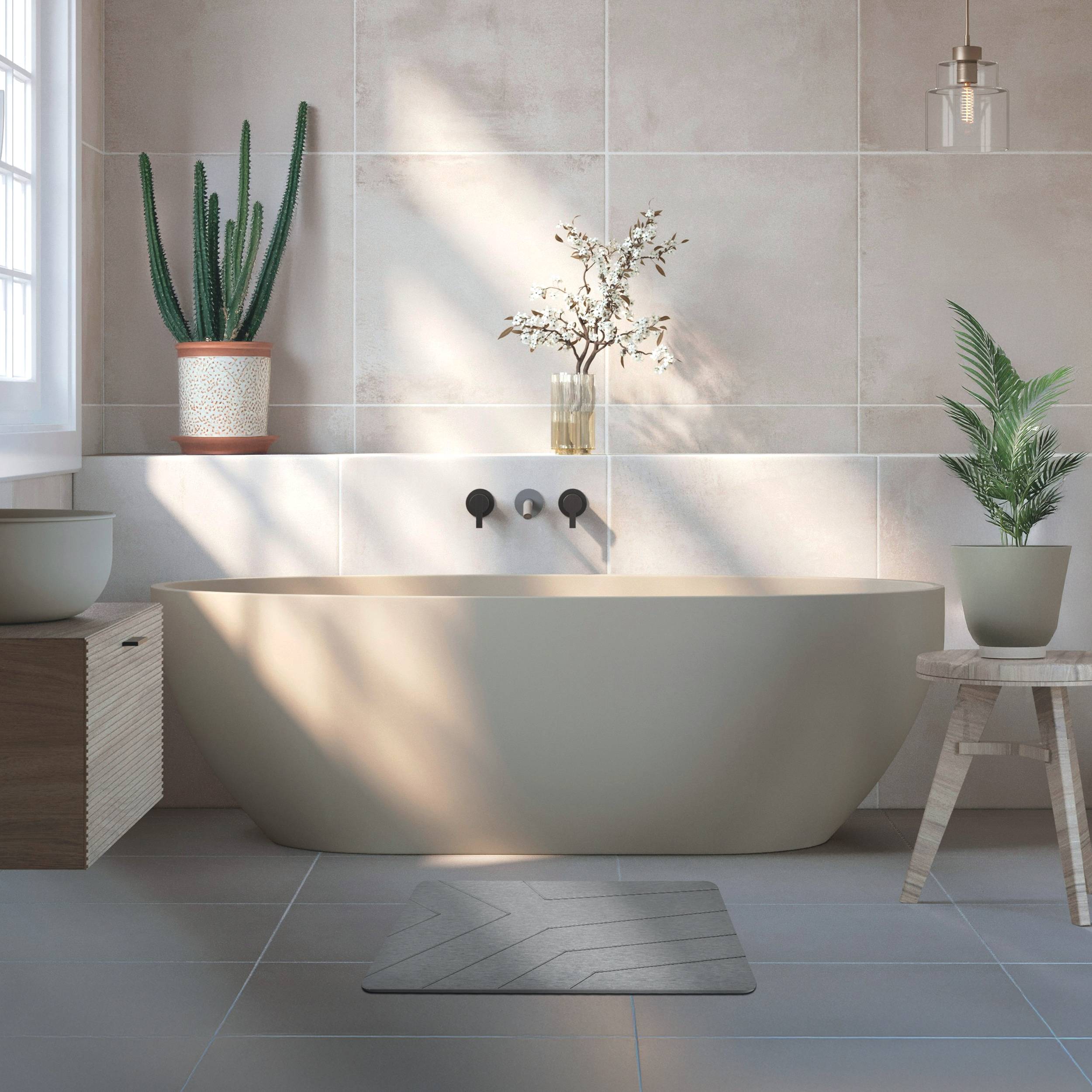 Modernes minimalistisches Badezimmer mit einer freistehenden Badewanne, Topfpflanzen und Sonnenlicht, das über gekachelte Wände und Boden strömt.