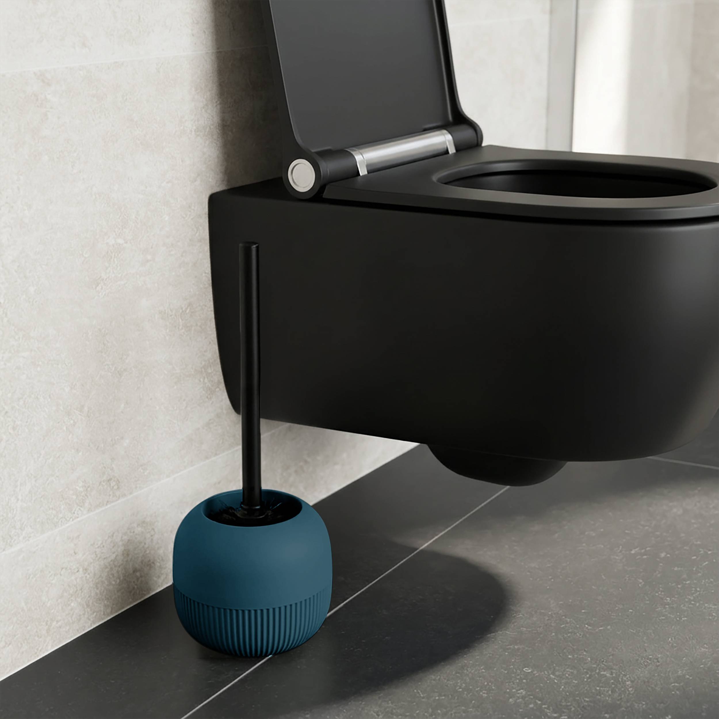 Eine schwarze an der Wand montierte Toilette mit geöffnetem Deckel und einer blauen Toilettenbürste in einem Halter daneben auf einem gefliesten Badezimmerboden.
