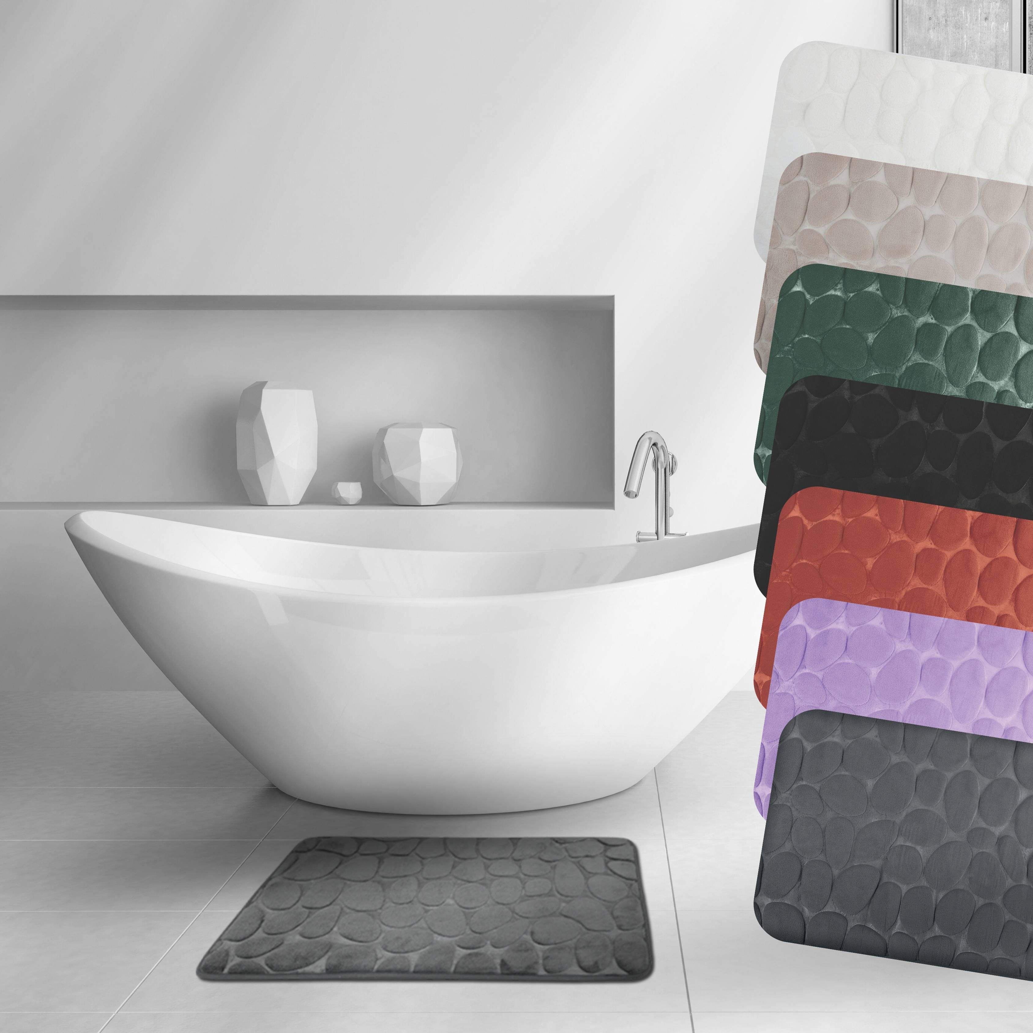 Modernes Badezimmer mit einer weißen freistehenden Badewanne, auf der rechten Seite ausgestellte Handtuch-/Teppichtexturen in mehreren Farben.