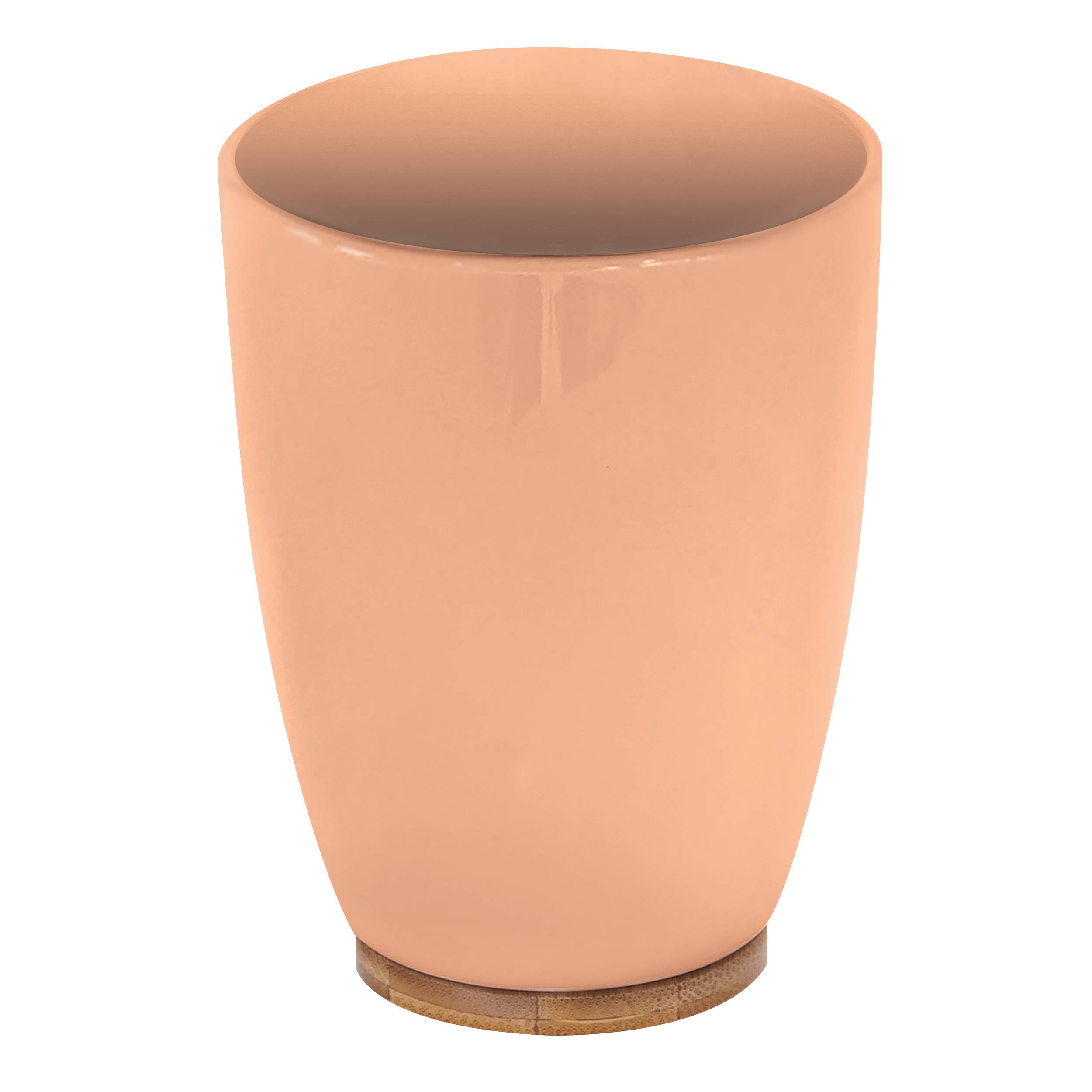 Pfirsichfarbener Keramikbecher oder Vase mit abgerundeter Form und offener Oberseite, vor weißem Hintergrund dargestellt.