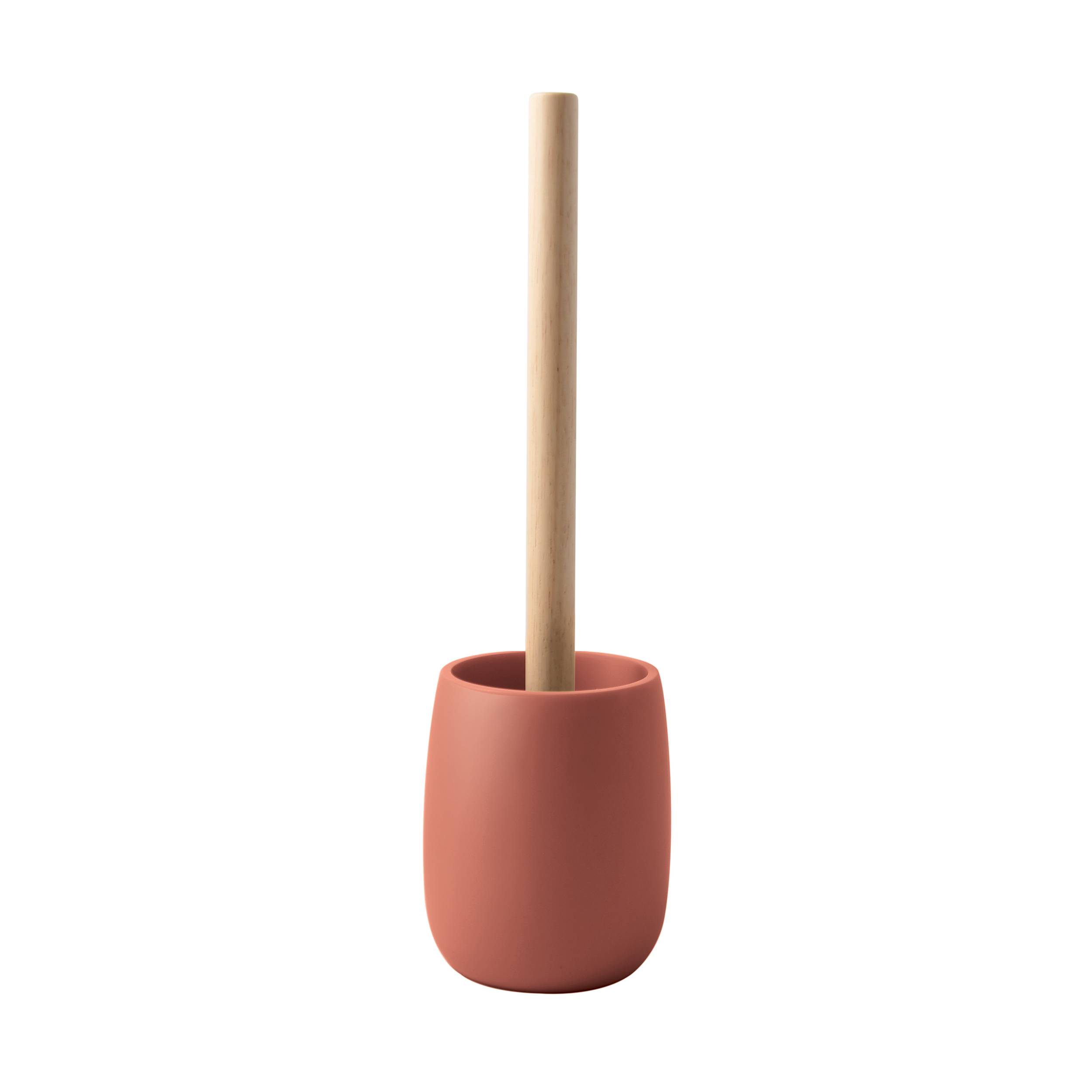 Eine Toilettenbürste aus Holz, die in einem rosa Halter auf weißem Hintergrund steht.