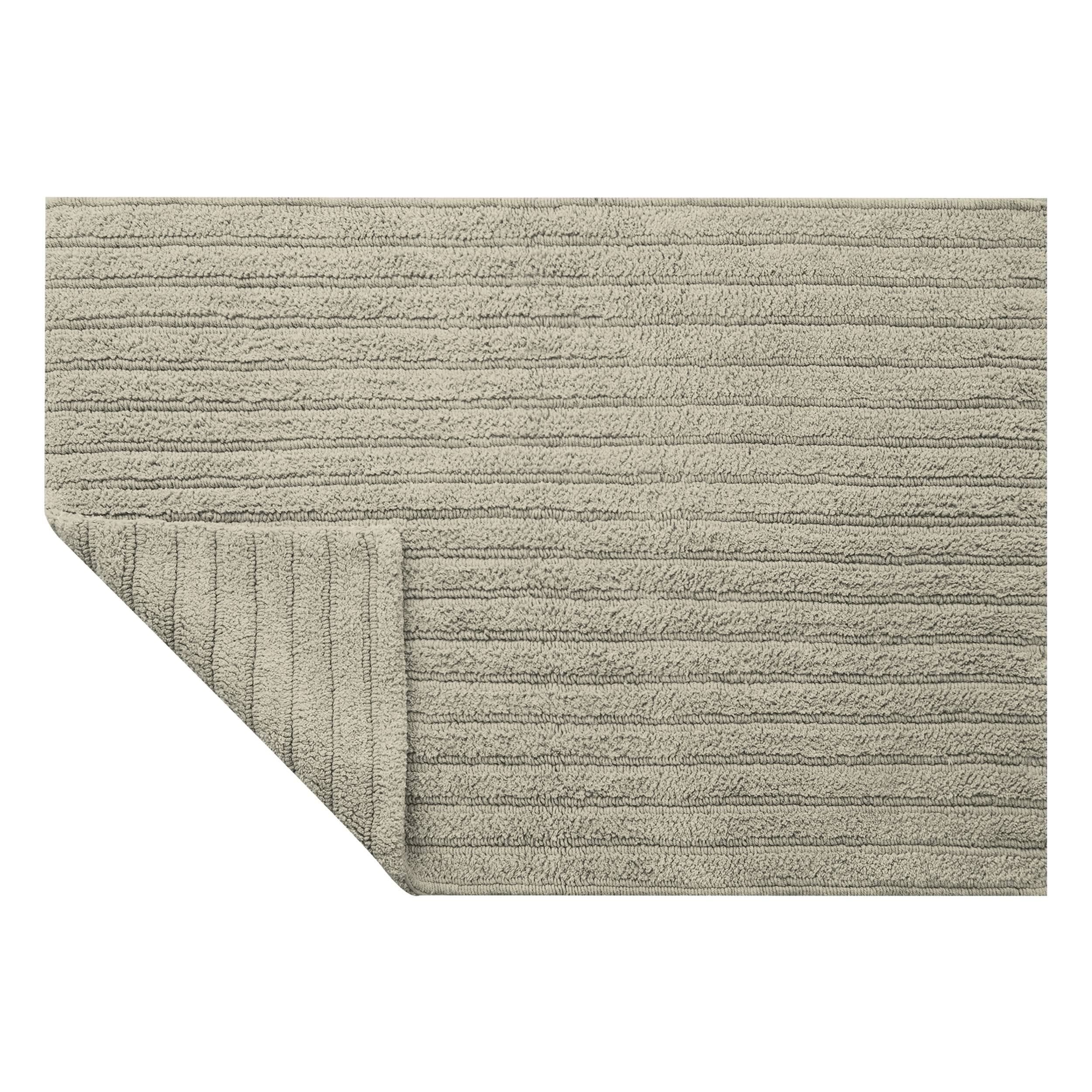 Beige strukturierter Stoff-Teppich, dargestellt mit einer hochgeklappten Ecke, die die Unterseite und die Rückseite zeigt.