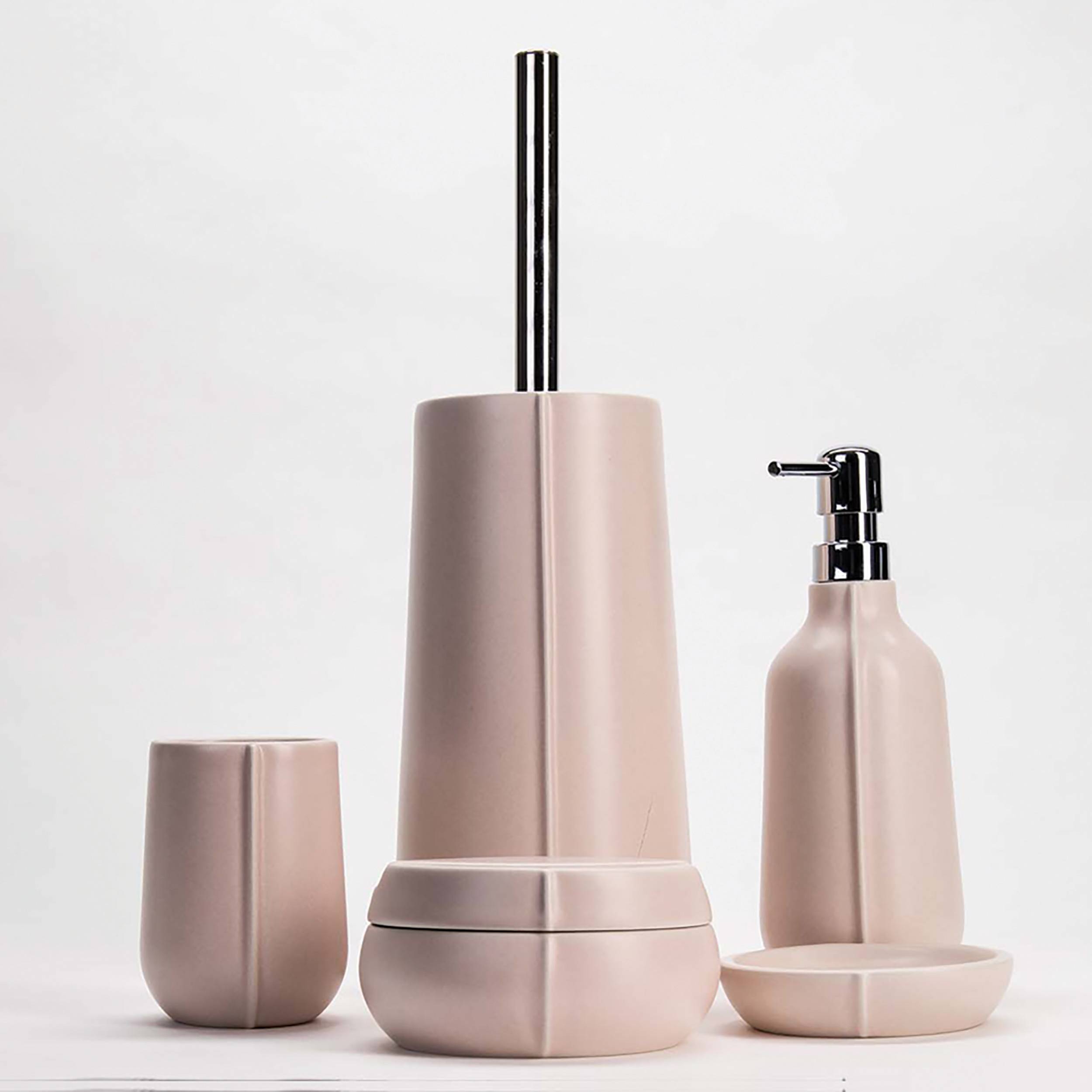 Satz matter rosa-rosa Badezimmeraccessoires: ein Zahnbürstenhalter, hoher Spender, Seifenflasche mit Pumpe und kleines Tablett auf weißem Hintergrund.