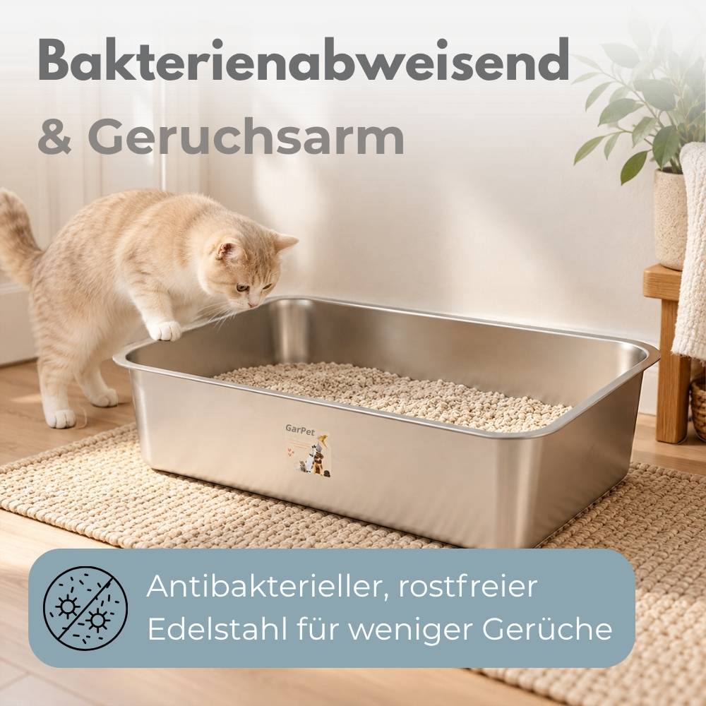 Eine Katze untersucht eine Edelstahl-Katzentoilette mit deutschem Text, der ein bakterienabweisendes, geruchsfreies, antibakterielles, rostfreies Design für weniger Gerüche bewirbt.