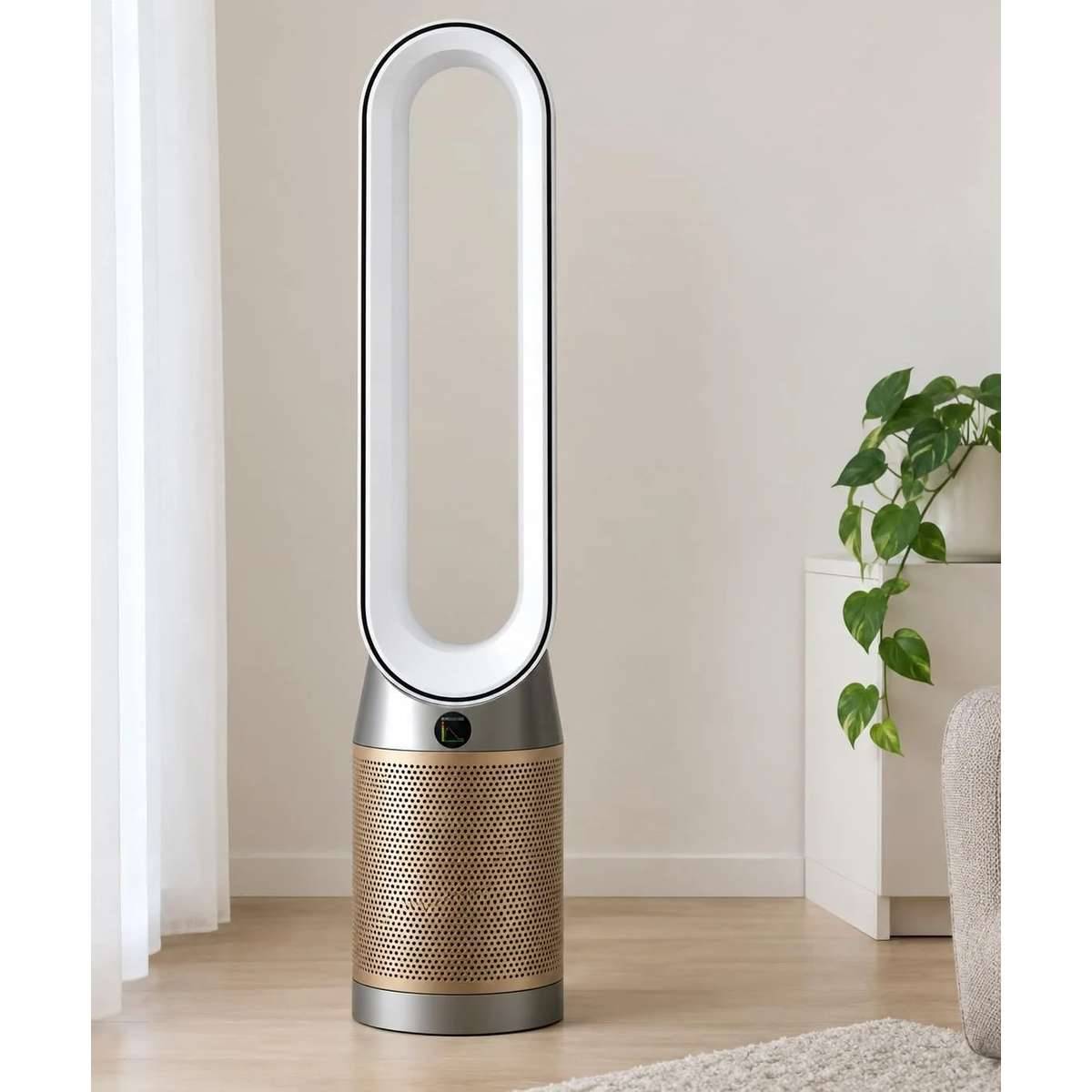 Ein blattloser Turmventilator mit einer goldfarbenen durchbrochenen Basis steht in einem minimalistischen Wohnzimmer neben einer Pflanze und einem Sofa.