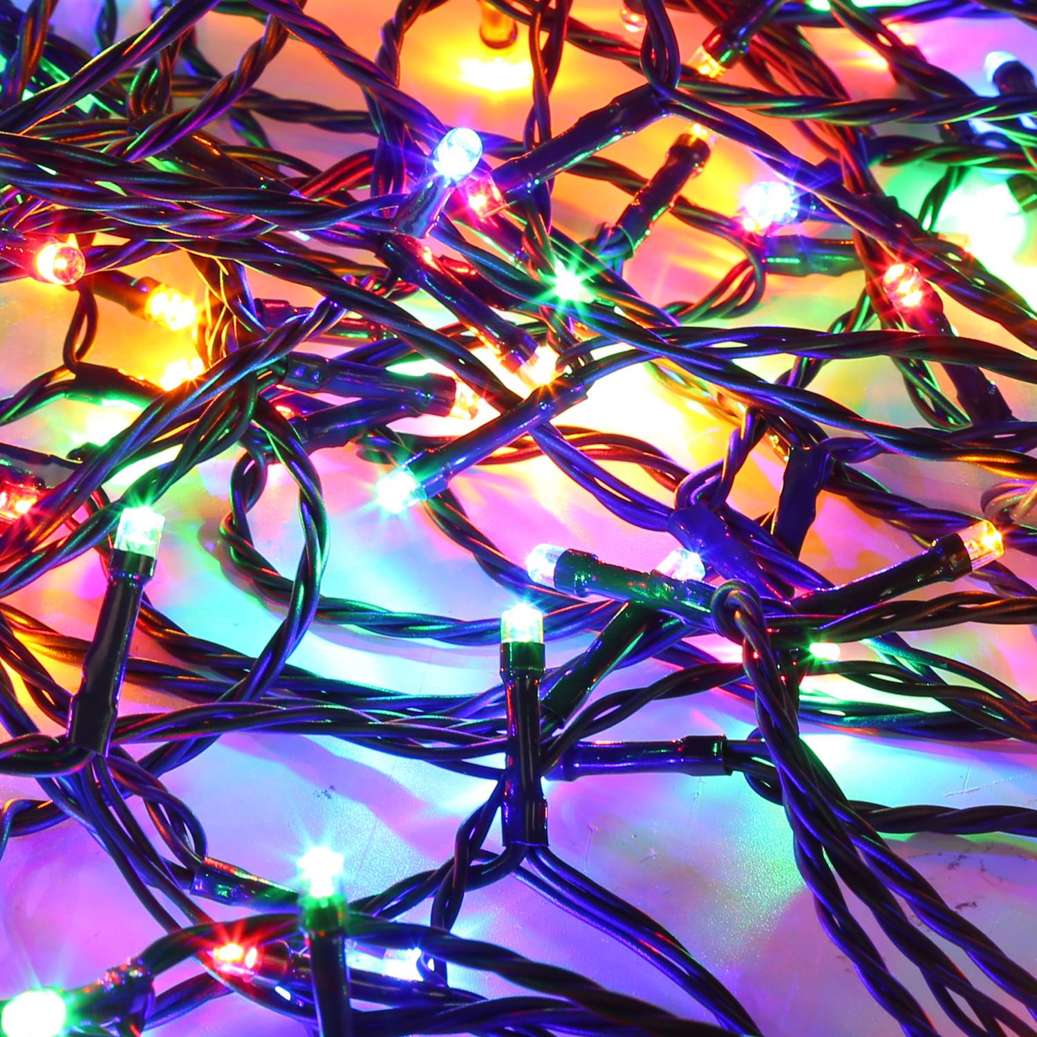 Verworrene mehrfarbige LED-Lichterketten, die hell auf einer weißen Oberfläche leuchten.