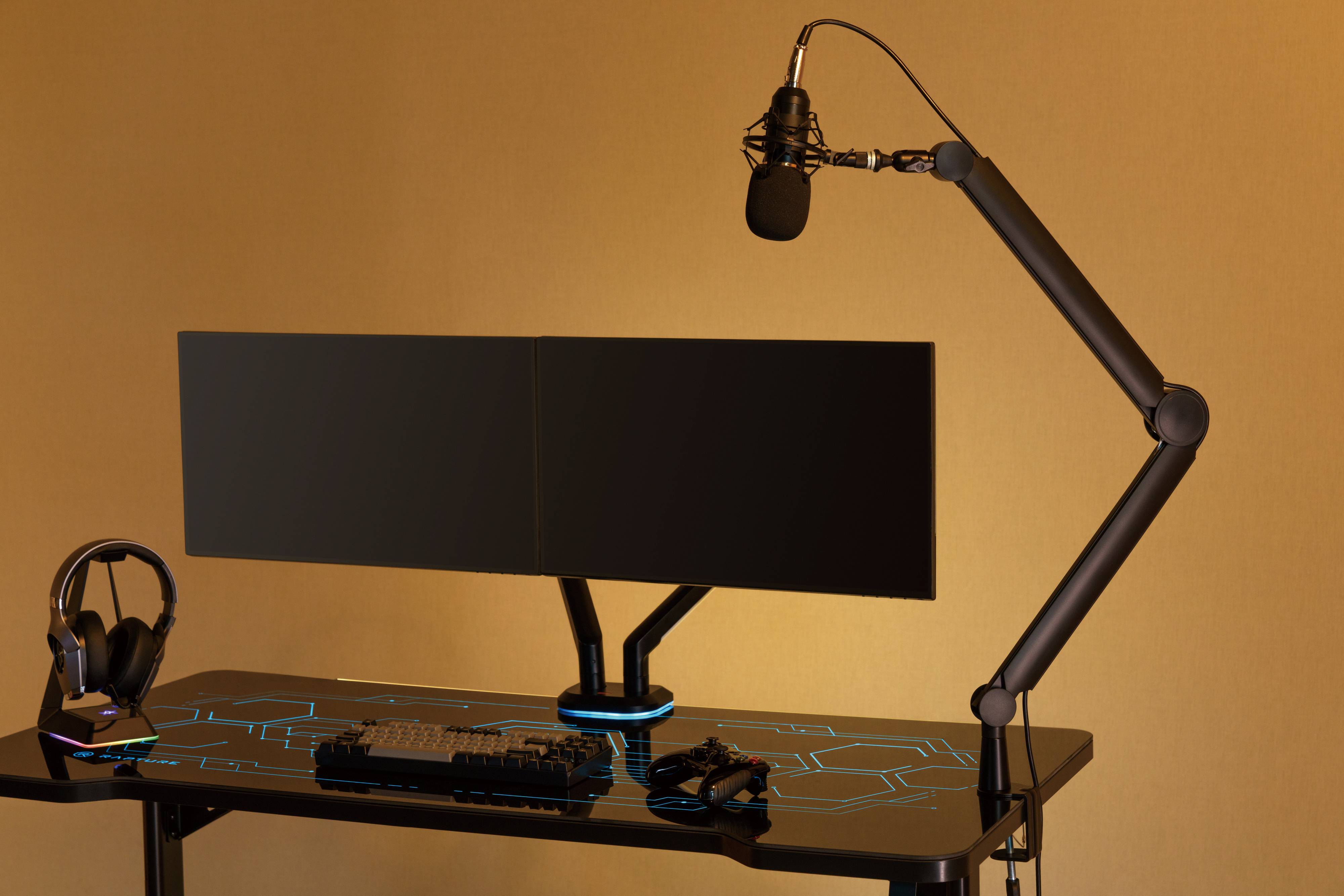 Gaming-Streaming-Setup mit einem Monitor, einer Tastatur, einer Maus, Kopfhörern und einem auf einem Ausleger montierten Mikrofon auf einem Schreibtisch