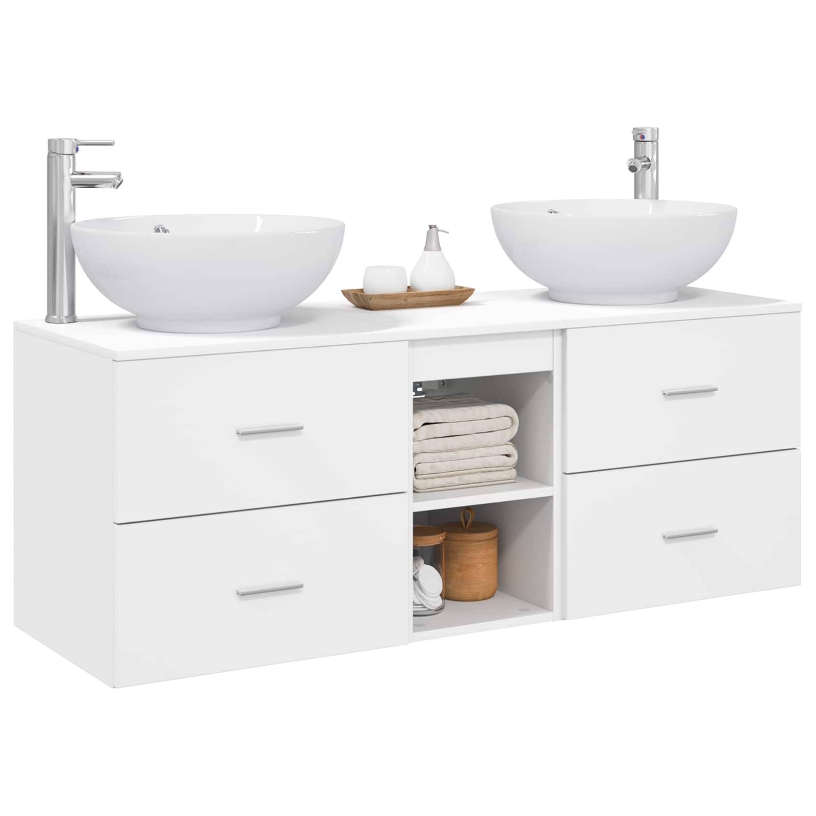 Weiße Badezimmerkommode mit Doppelwaschbecken, zwei Chromarmaturen, vier Schubladen und offenen mittleren Regalen mit gefalteten Handtüchern und Toilettenartikeln.