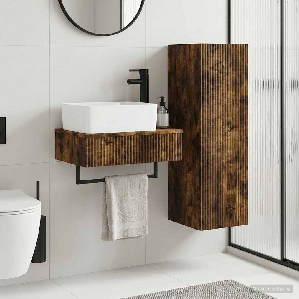 Modernes Badezimmer mit an der Wand montiertem weißem Waschbecken, Holz-Waschtischschrank, Toilette, Handtuch und hohem Holz-Lagerschrank neben einer Duschabtrennung aus Mattglas.