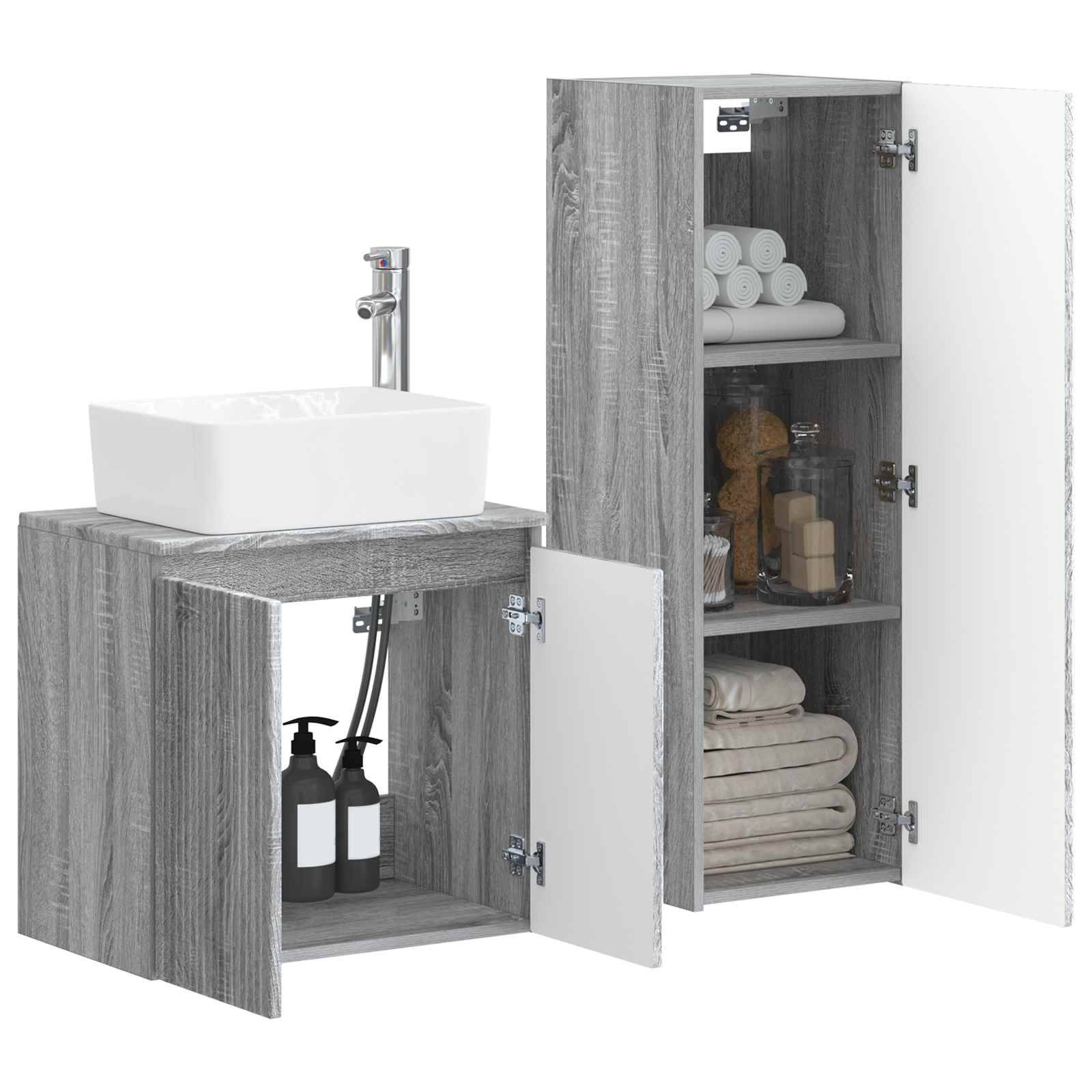 Zwei graue Holz-Badezimmerschränke mit weißen Waschbecken, offene Türen zeigen Regale mit Handtüchern, Toilettenartikeln und anderen Badezimmergegenständen.