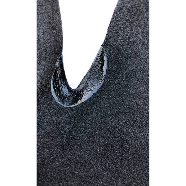 Nahaufnahme eines dunklen, strukturierten Materials mit einem V-förmigen Ausschnitt, das eine glänzend schwarze innere Oberfläche freilegt.
