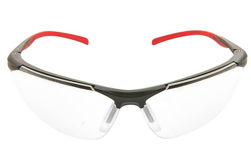 Klare Schutzbrille mit roten Bügeln und schwarzem Rahmen, vor weißem Hintergrund abgebildet.
