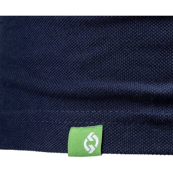 Nahaufnahme eines dunkelblau strukturierten Stoffes mit einem kleinen grünen Etikett, das ein weißes, recyclingartiges Schleifensymbol nahe der unteren Kante aufweist.